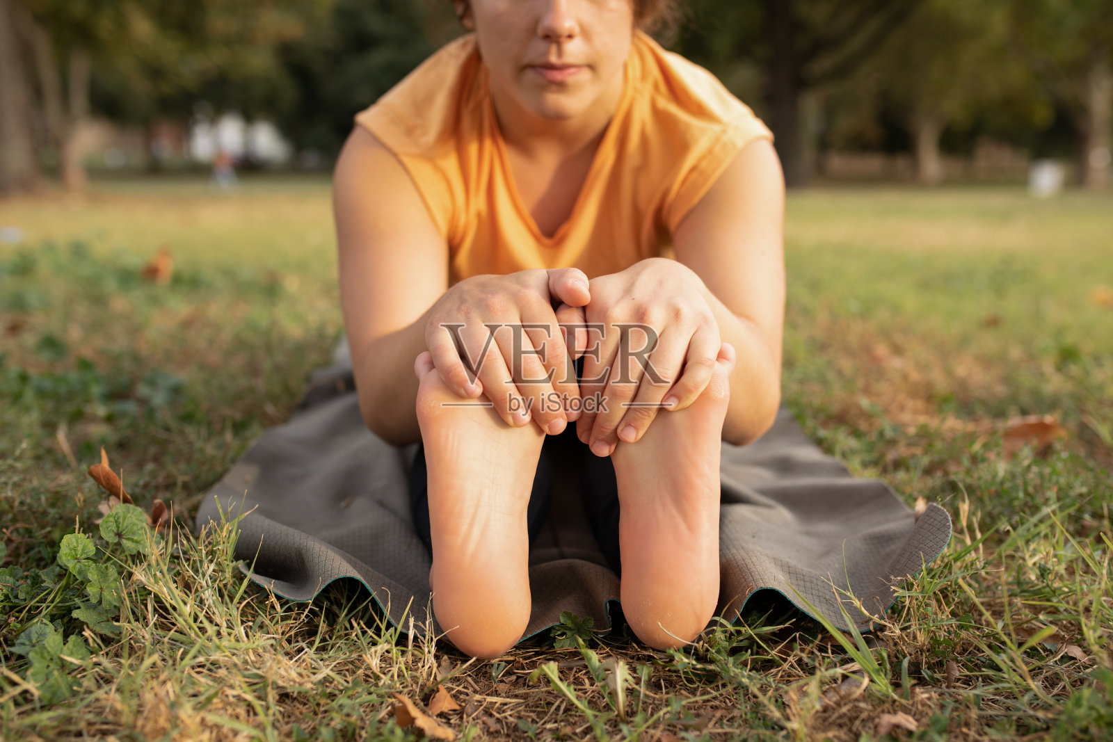 年轻女子在公园里做瑜伽照片摄影图片