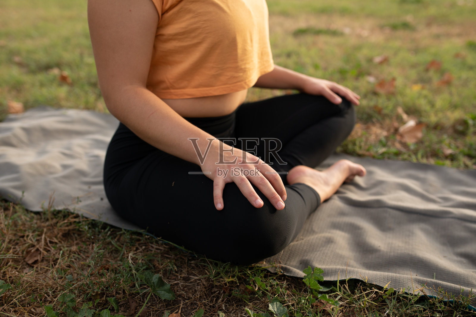 近距离观察一个陌生的年轻女子在公园里做瑜伽照片摄影图片