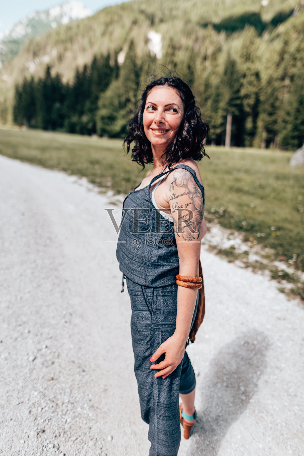 在白云石上微笑的纹身女人照片摄影图片