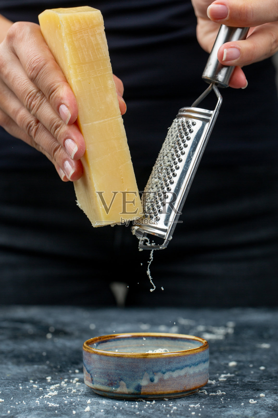 烹饪过程中被女人磨碎的奶酪照片摄影图片