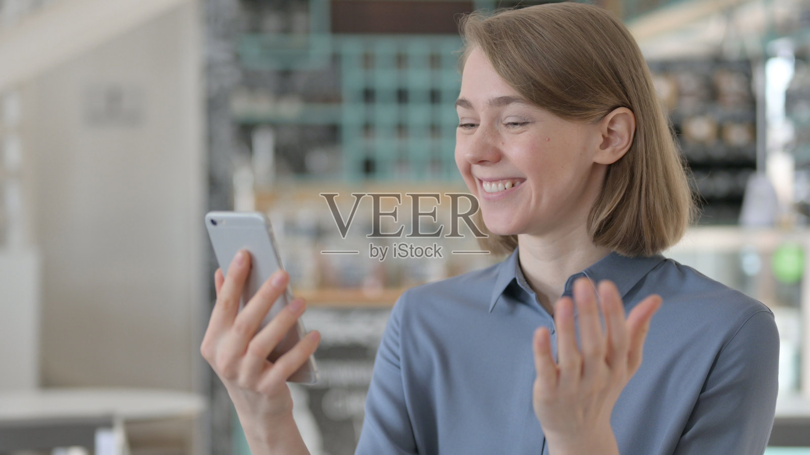 年轻女性在智能手机上庆祝成功的肖像照片摄影图片