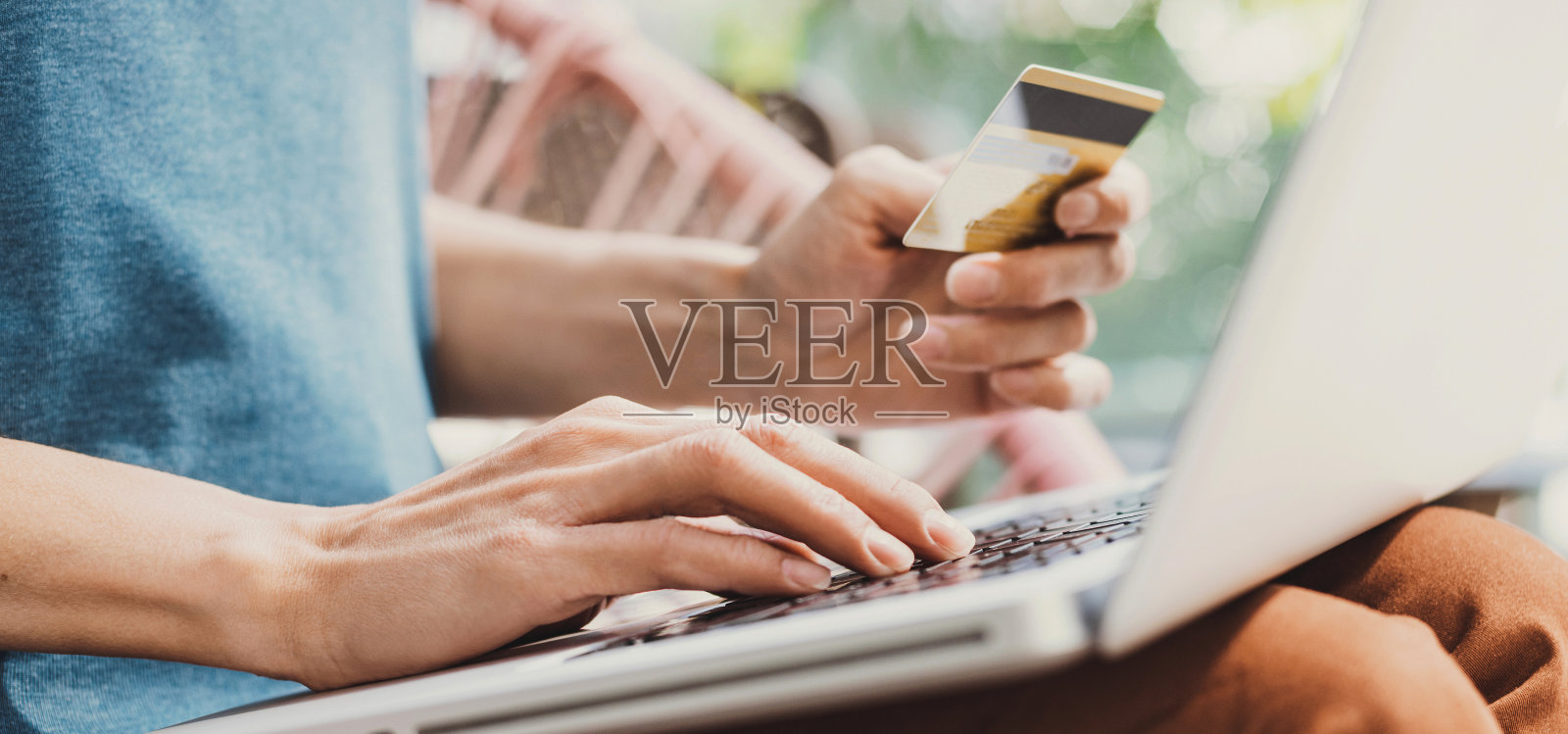 女人在户外用笔记本电脑和信用卡在线订购照片摄影图片