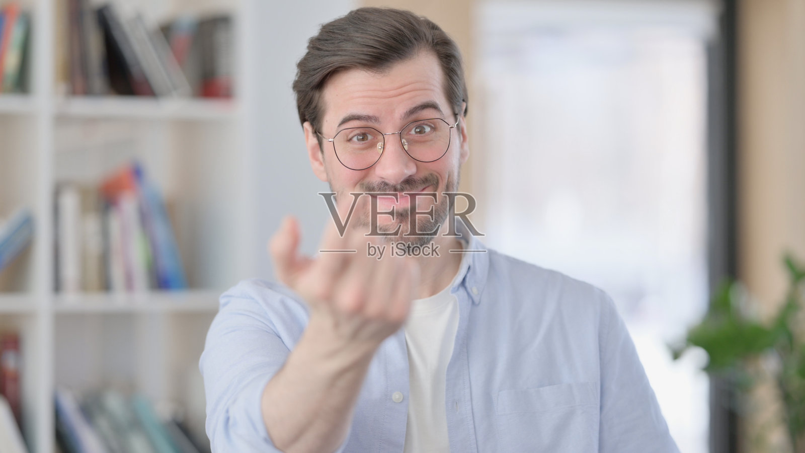 戴眼镜的男人对着相机的肖像，邀请照片摄影图片