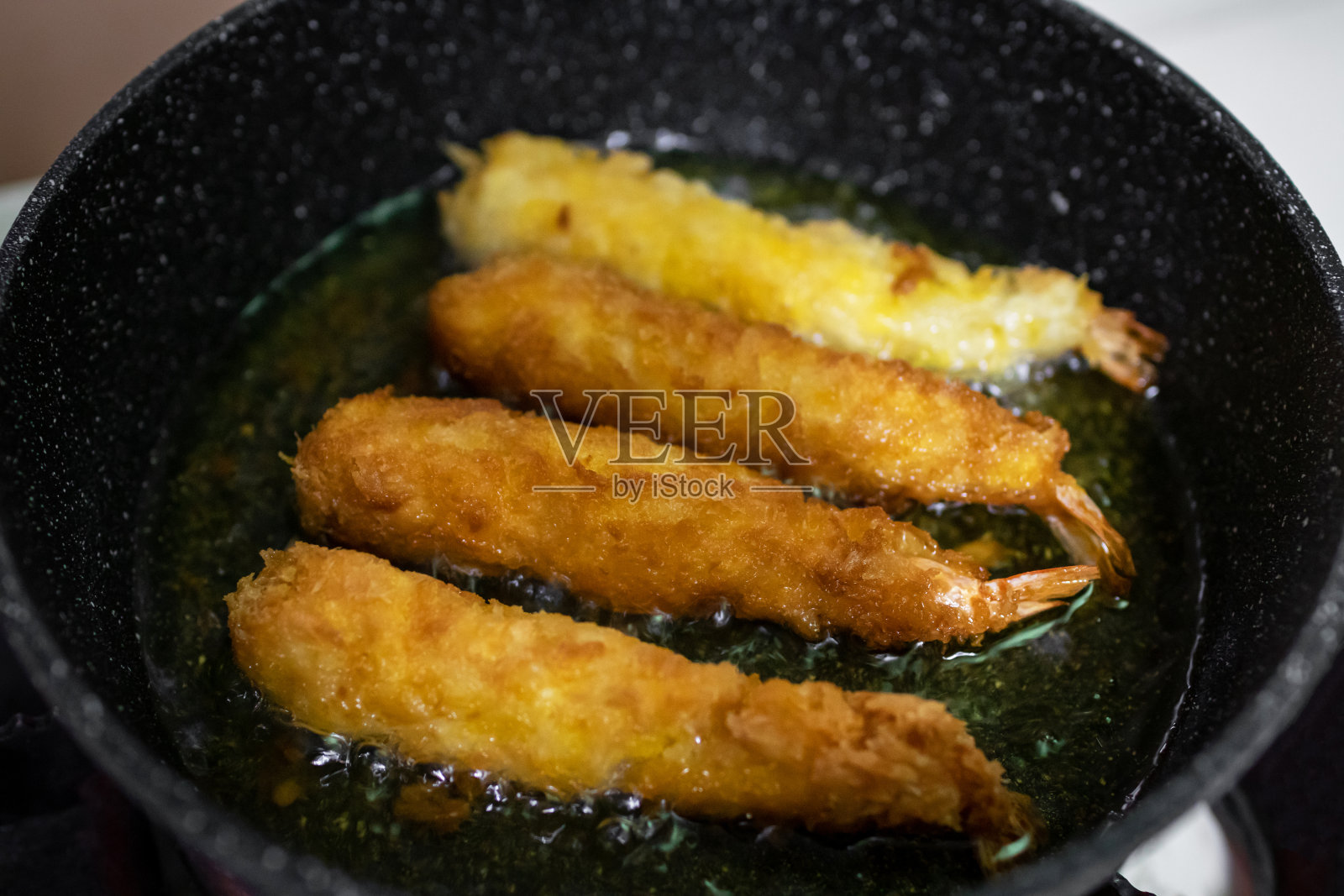 在平底锅上煎炸香脆的天妇罗炸虾。照片摄影图片