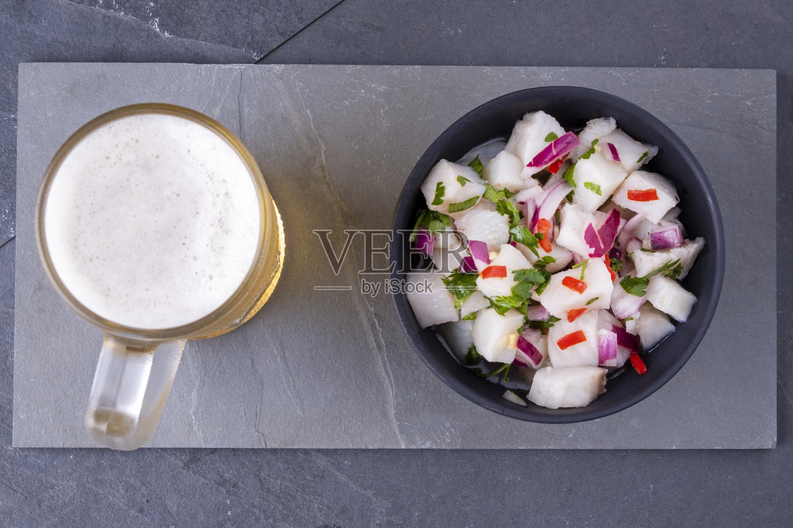 一碗酸橘汁腌鱼和一杯冰啤酒照片摄影图片