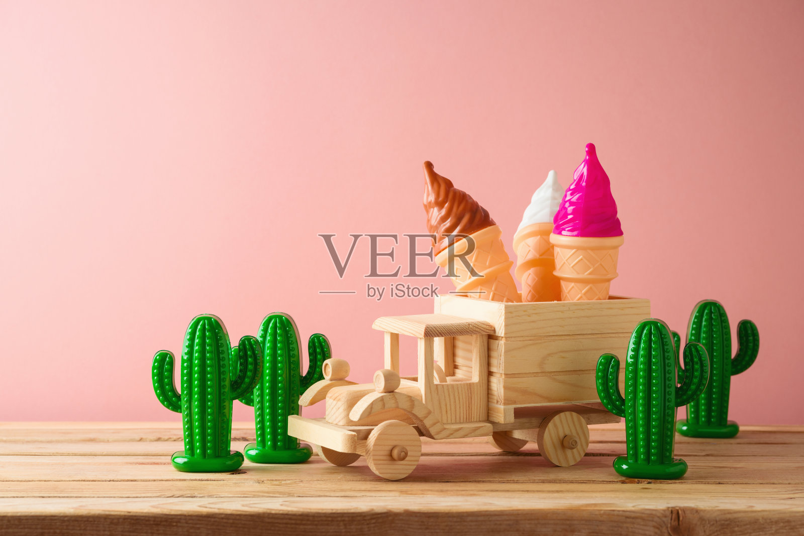 暑期概念与玩具卡车，冰淇淋和仙人掌木桌子上的粉红色背景。照片摄影图片