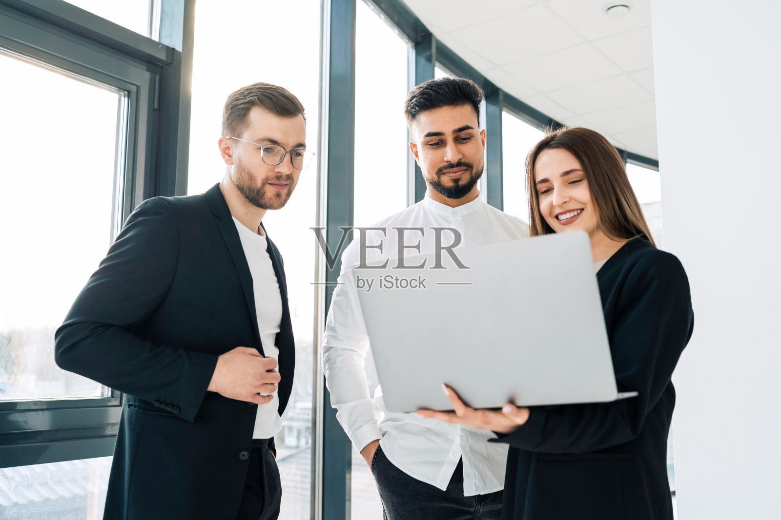 一群商务人员在办公室里找笔记本电脑。秘书向老板汇报工作照片摄影图片