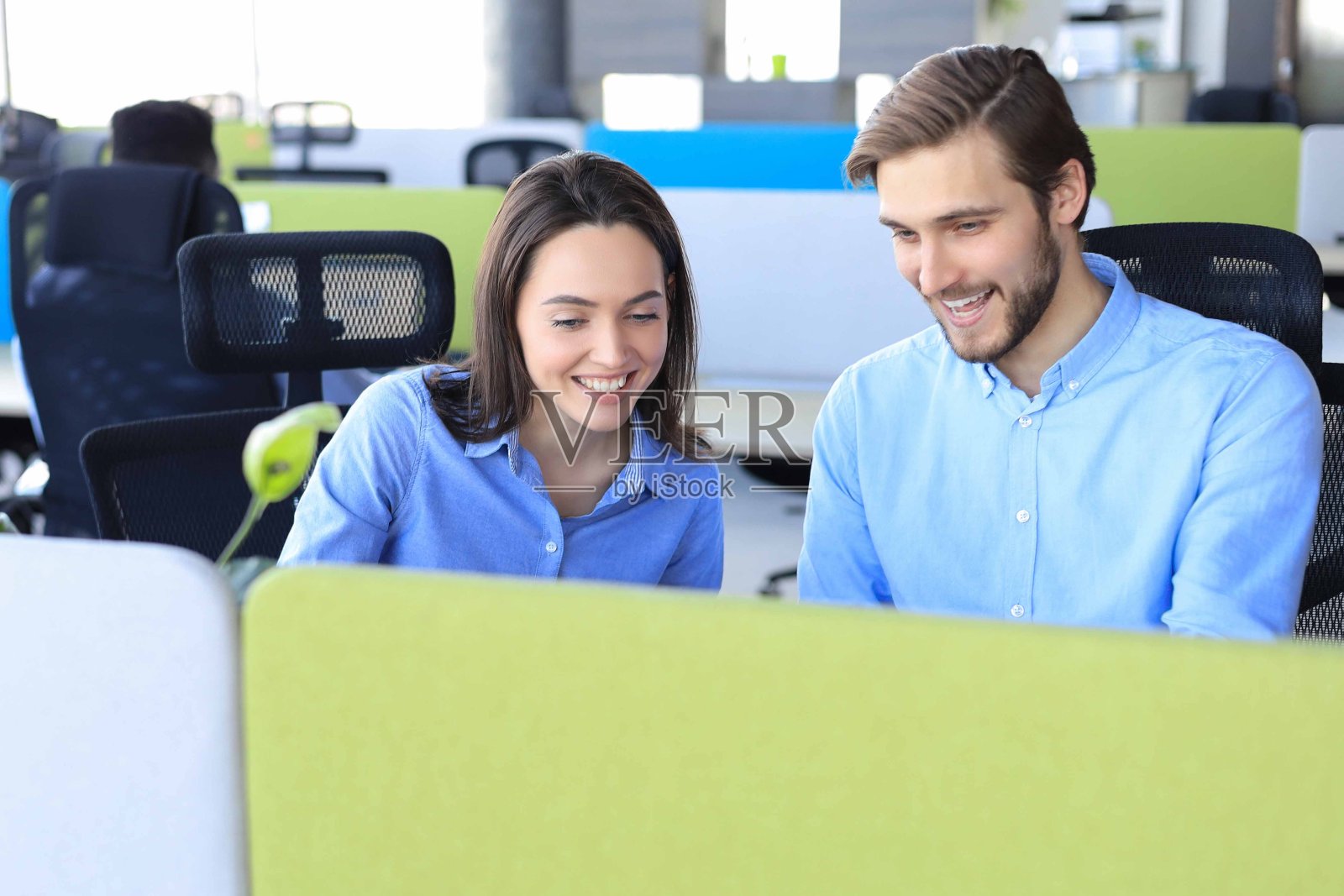 两个同事在办公室讨论文件和其他工作时刻。照片摄影图片