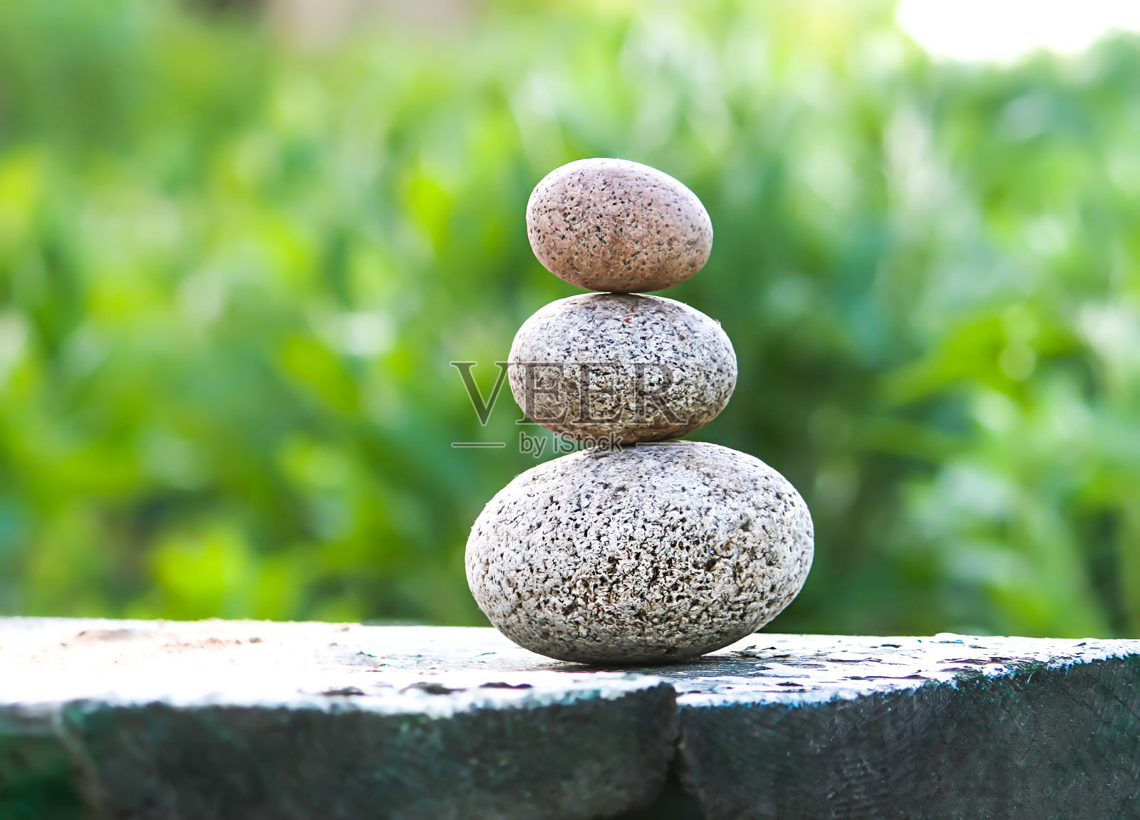 三块石头放在一张木桌上照片摄影图片