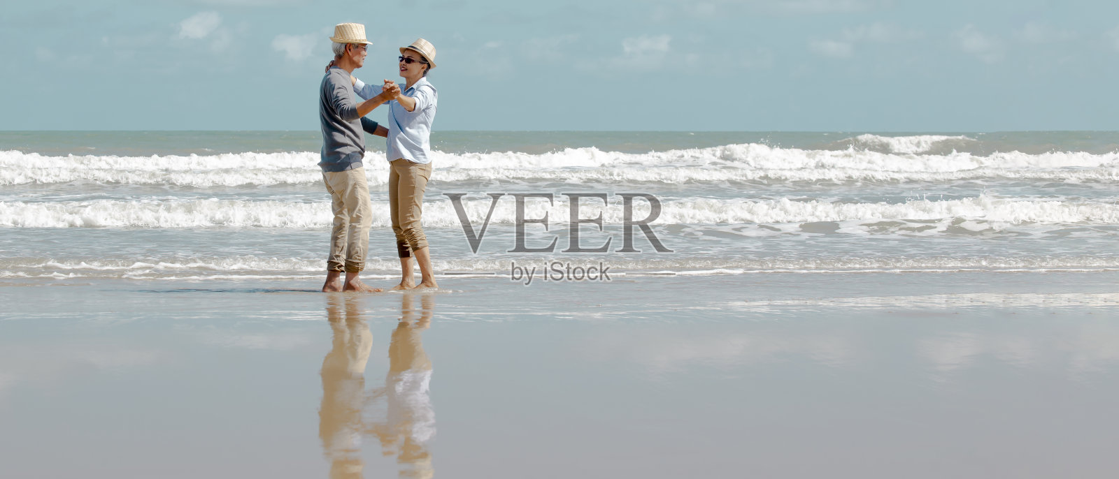 一对亚裔老年情侣在海滩上跳舞照片摄影图片