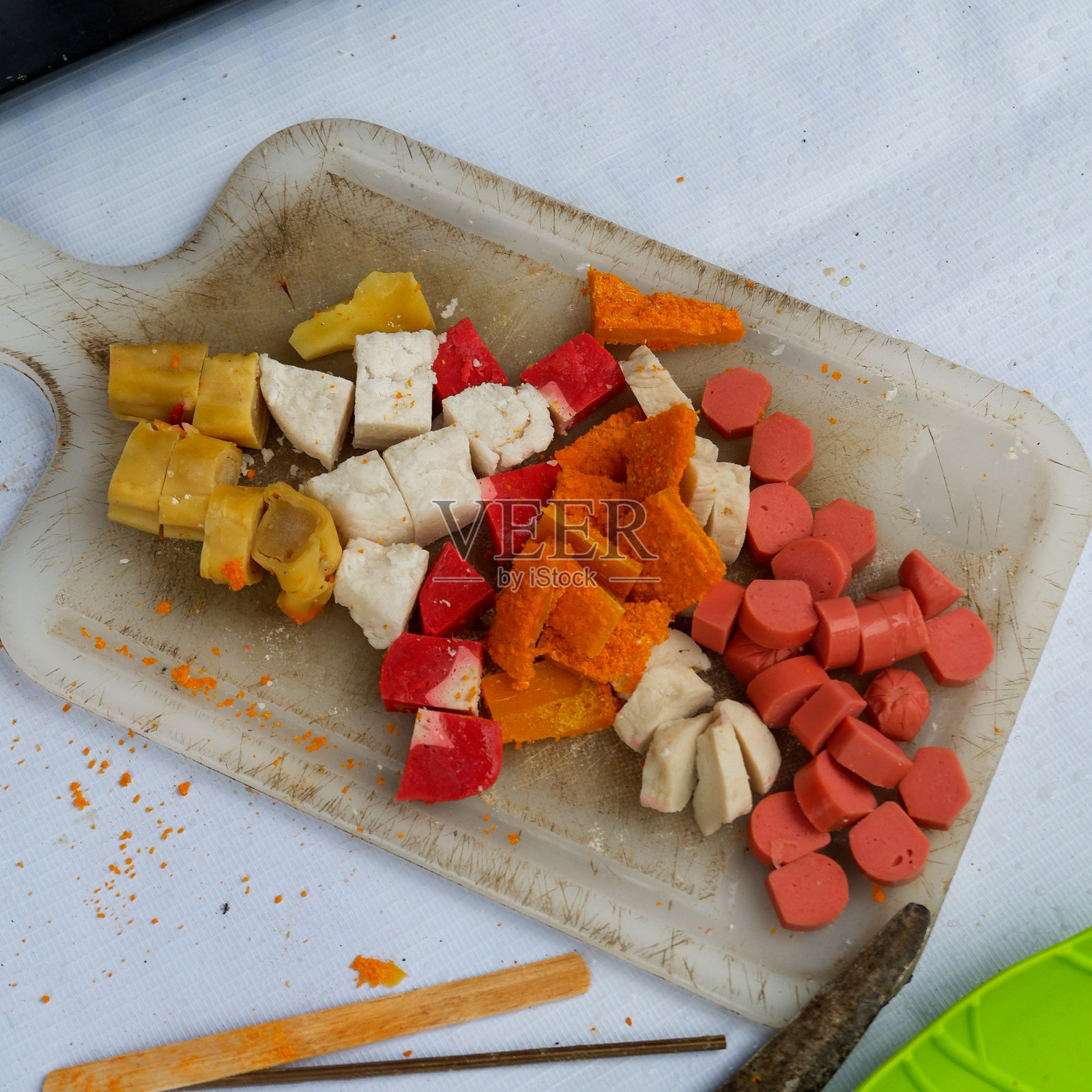 小吃照片包括炸香肠、炸鸡块、炸豆腐和浇上香料的煎饺子照片摄影图片