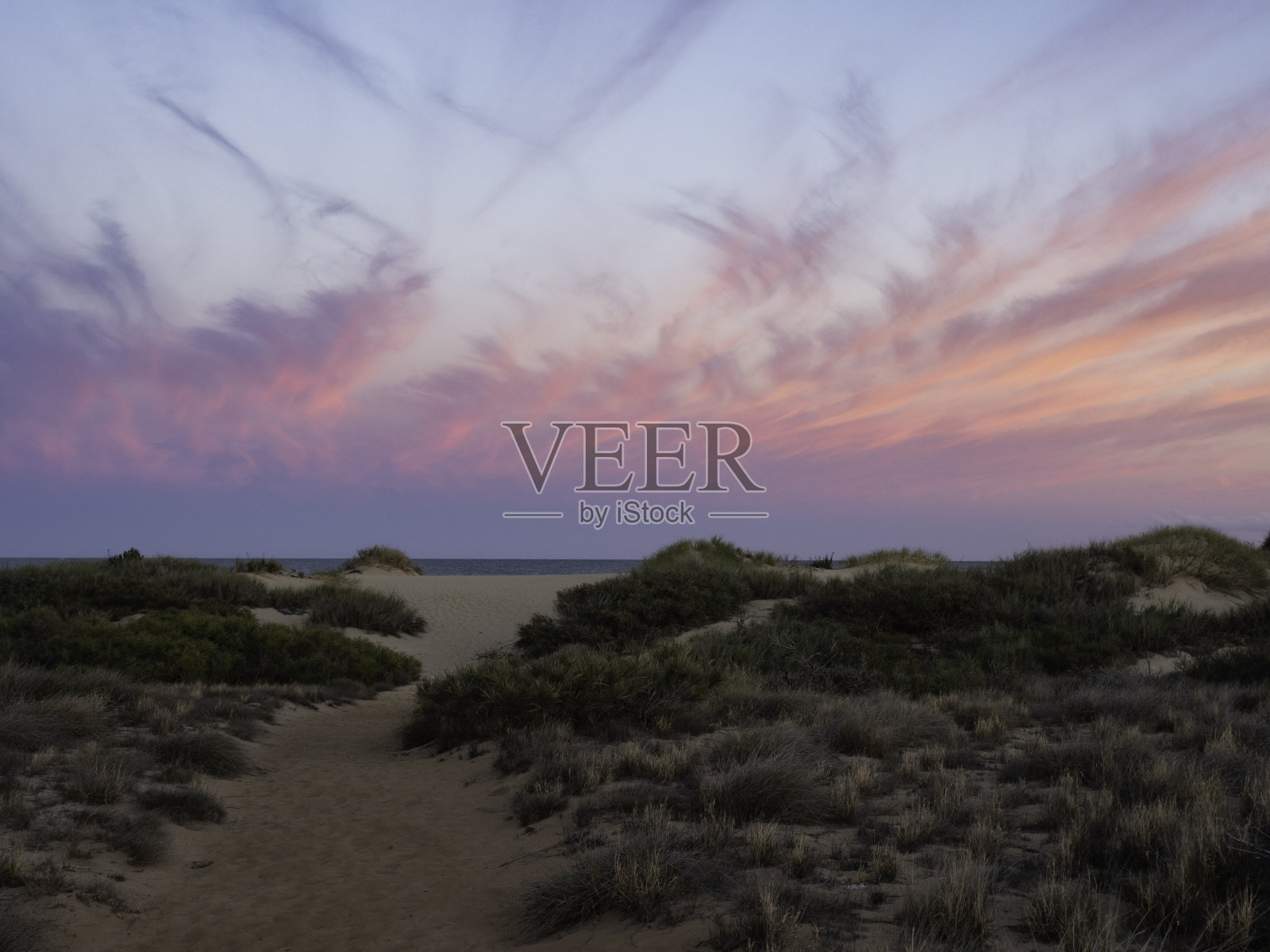 蜿蜒的小径穿过沙丘到达海滩照片摄影图片