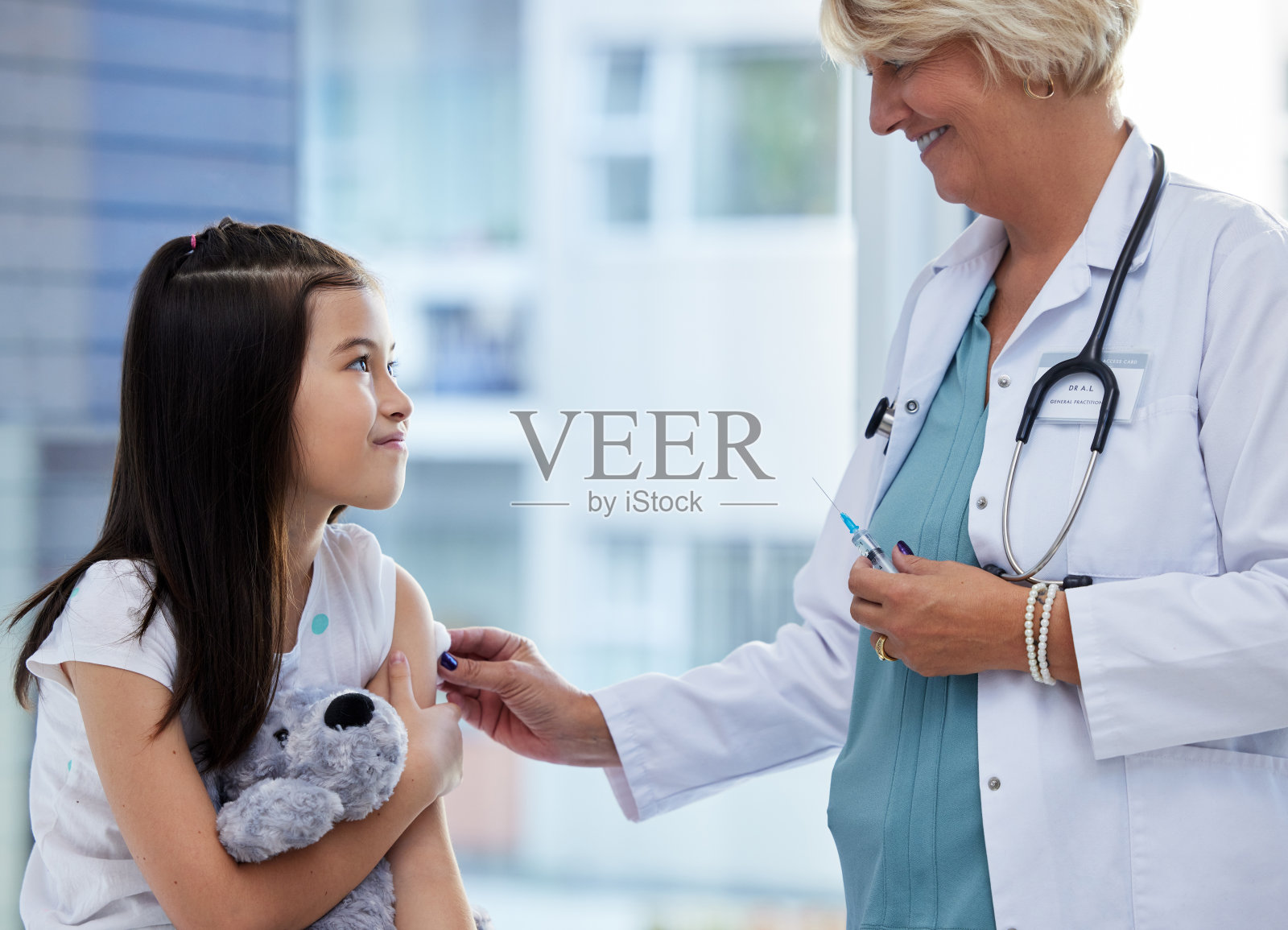 一个小女孩在医院里接受医生的疫苗注射照片摄影图片