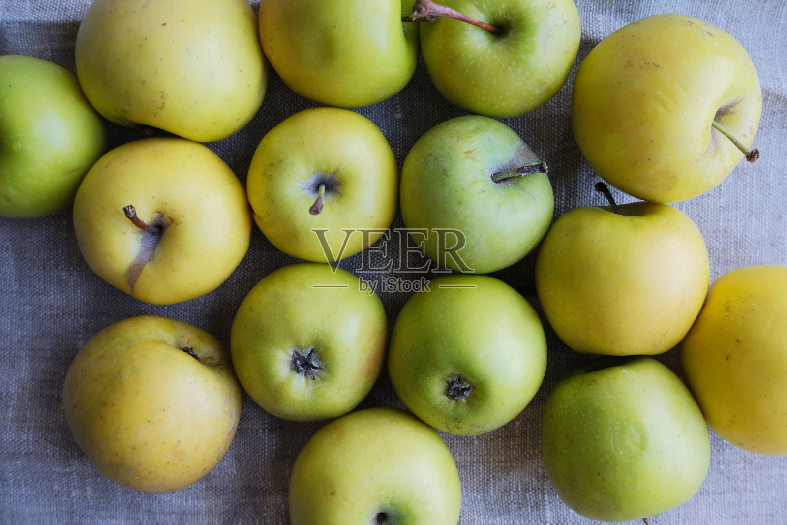 绿色和黄色的苹果在画布上。照片摄影图片