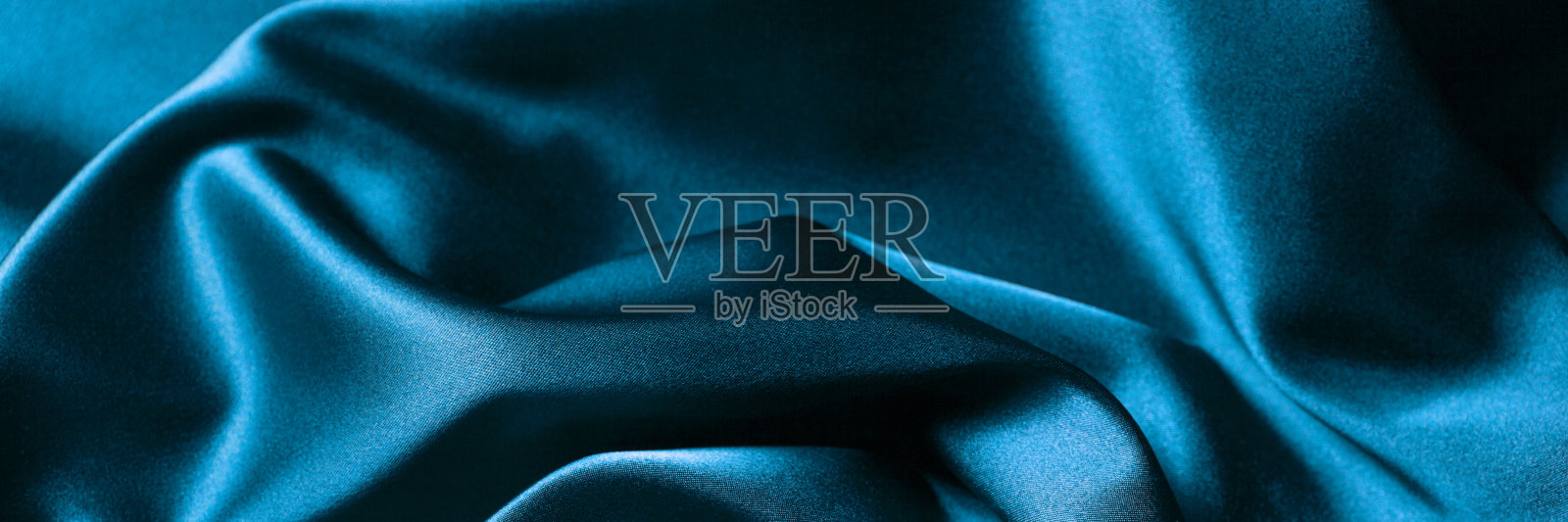 抽象的蓝色背景的豪华布料或液体波浪或波浪褶皱的污浊丝绸质地的缎子材料。照片摄影图片