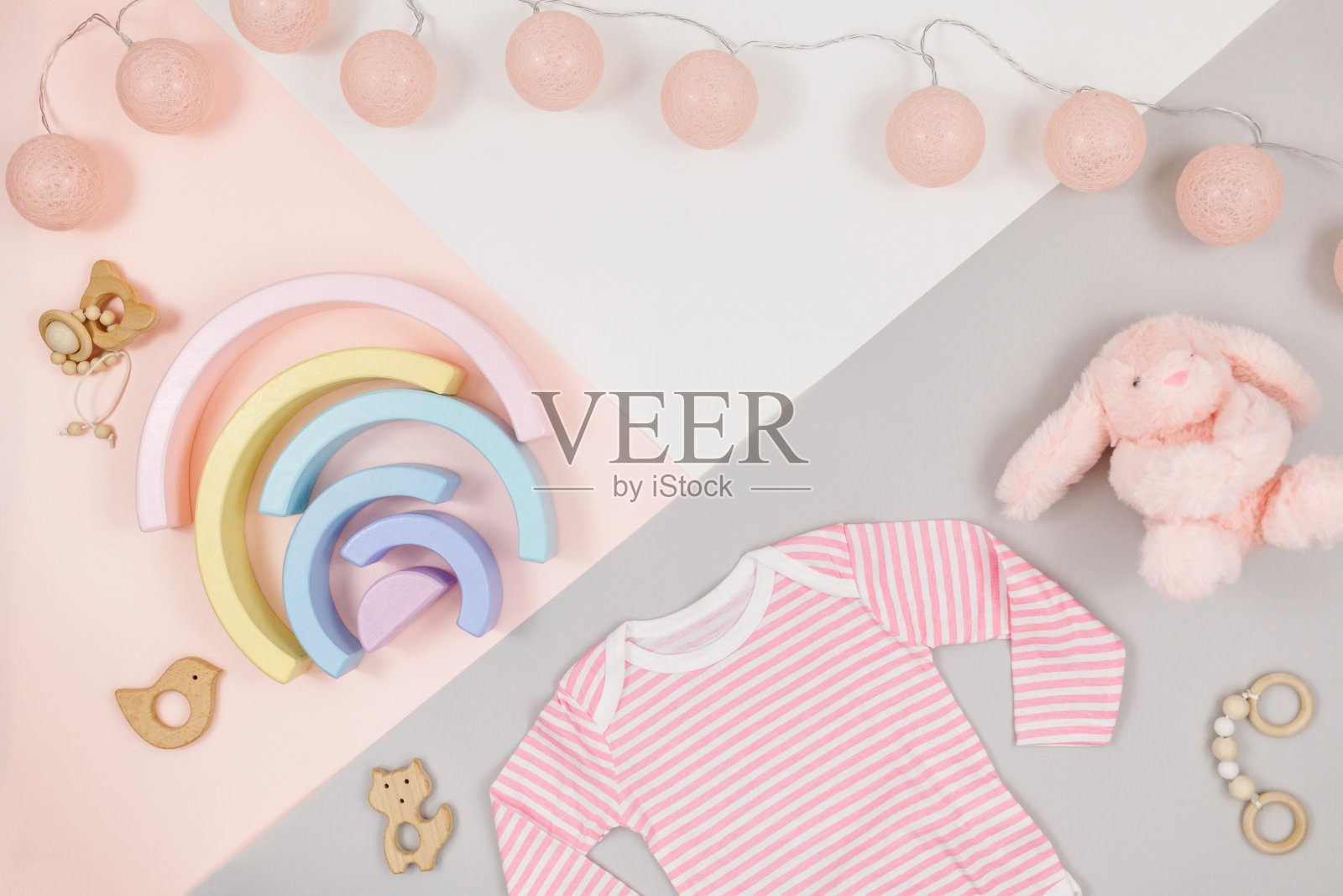 粉红色的玩具熊和粉红色的紧身衣，由棉花和木制玩具为新生儿。模拟了照片摄影图片