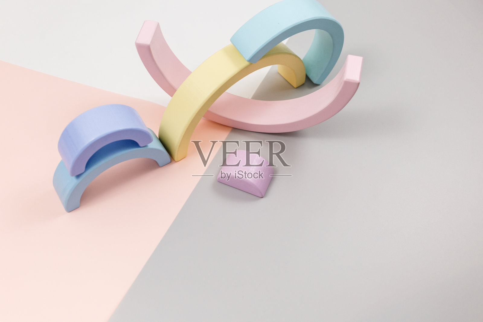 几何木形状在粉红色的灰色背景。幼儿园、学前班或日托所的创意玩具。照片摄影图片