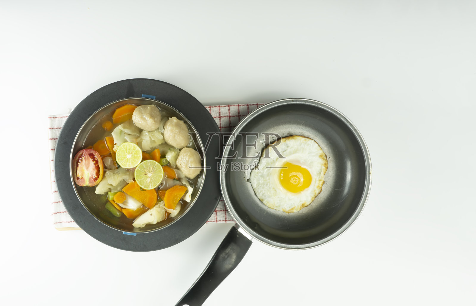 白色背景上的餐巾上的煎蛋卷和肉丸汤。照片摄影图片