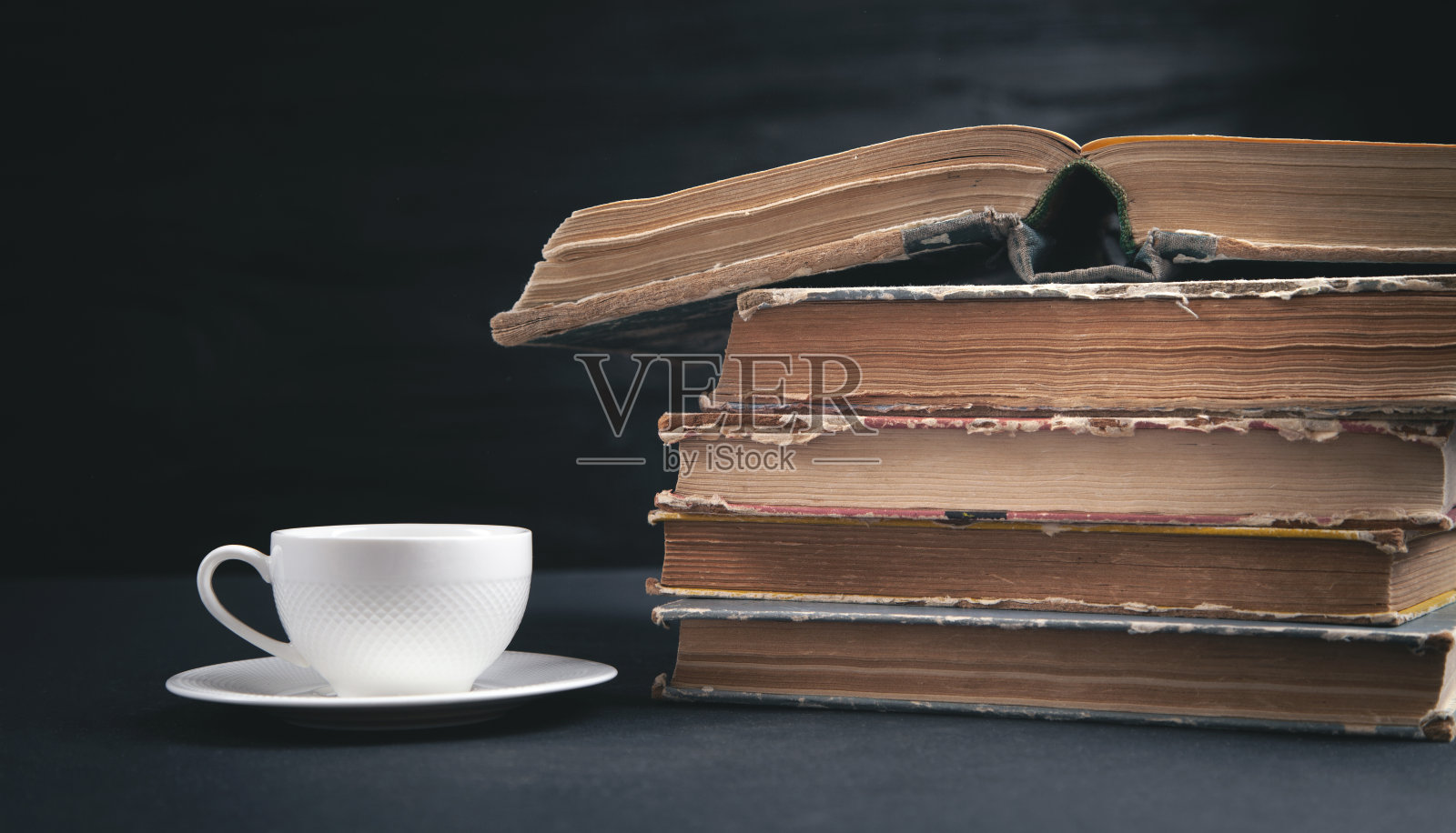 把书和咖啡放在黑色的背景上。照片摄影图片