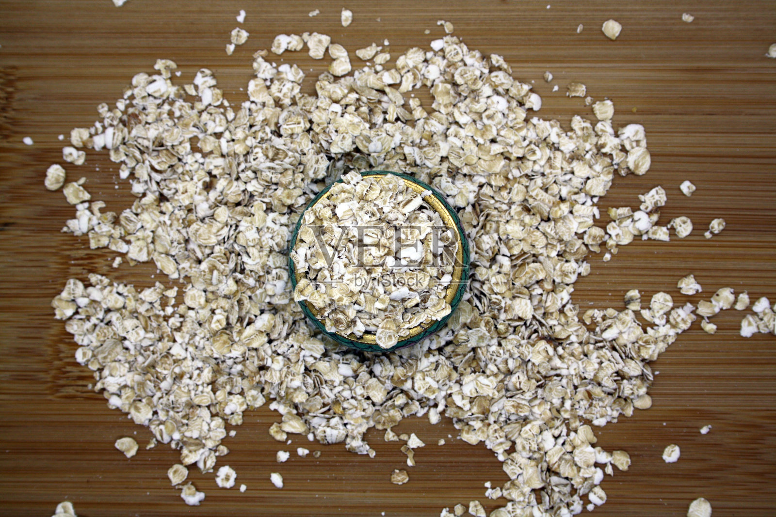木质背景上的中粒燕麦片。照片摄影图片
