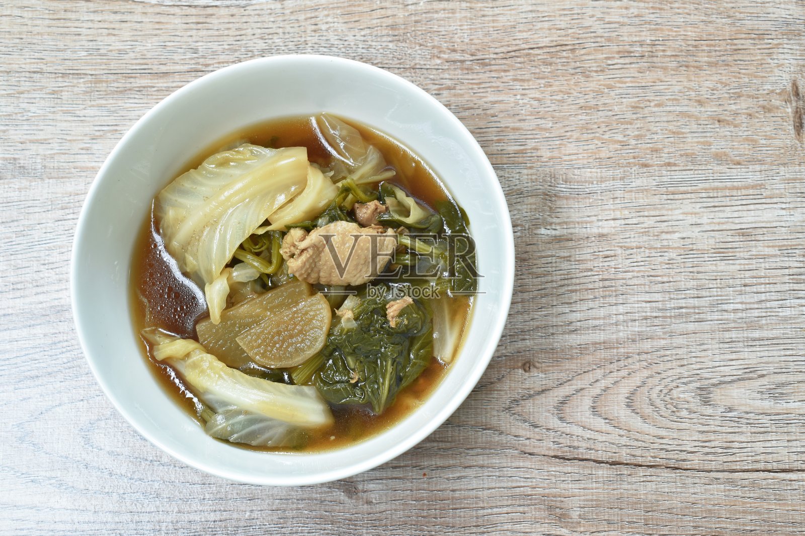 用黑豆汤将青菜与鸡肉煮在碗中照片摄影图片