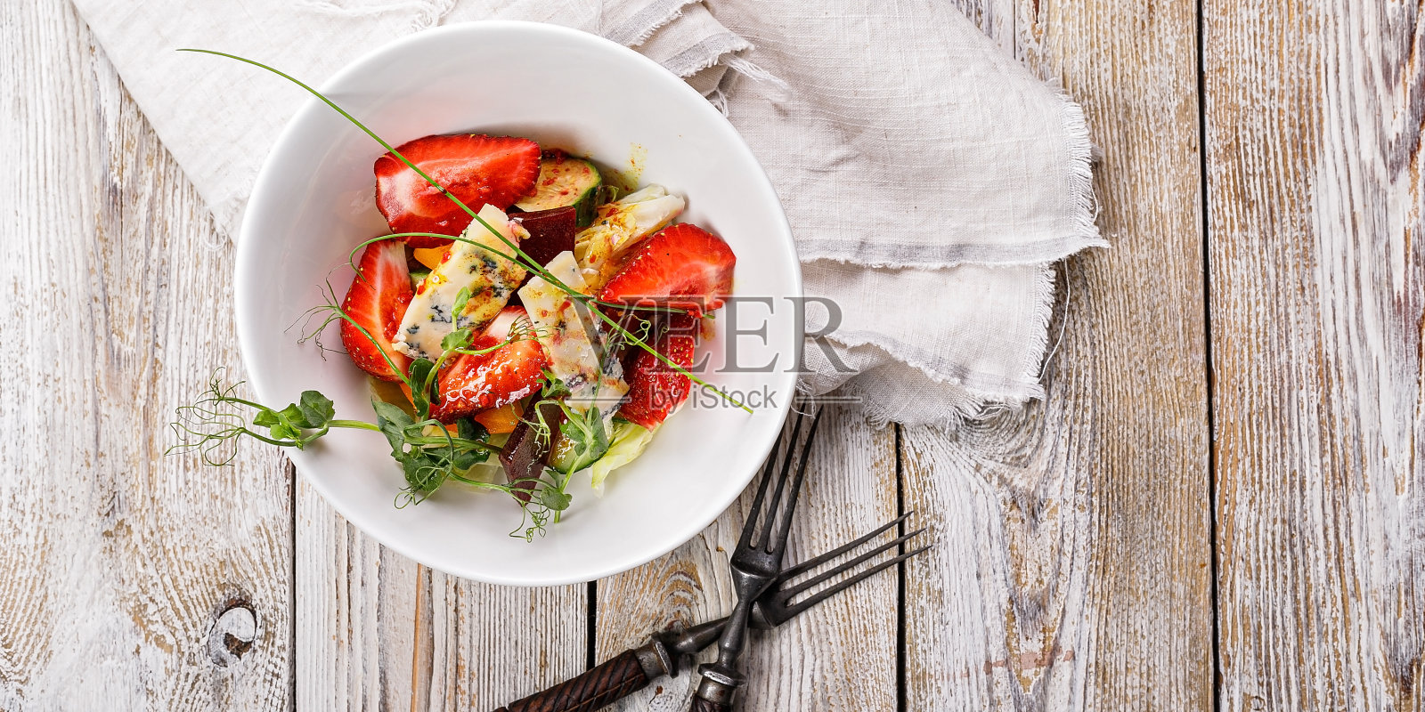 食物的旗帜。美味的夏日沙拉。新鲜的草莓，烤甜菜，黄色的西红柿，或蓝色的奶酪和香草放在一个白色的碗里，在一个淡淡的乡村背景。Summerfood。本空间照片摄影图片