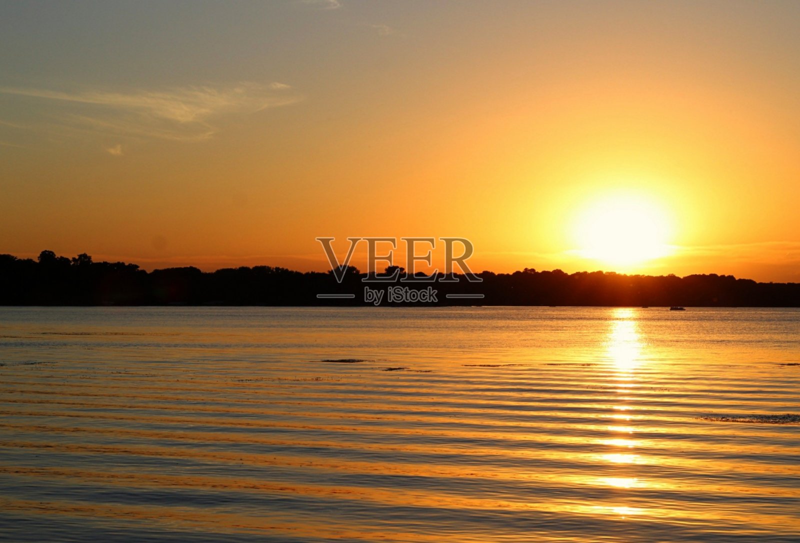 夕阳在荡漾的水面上照片摄影图片