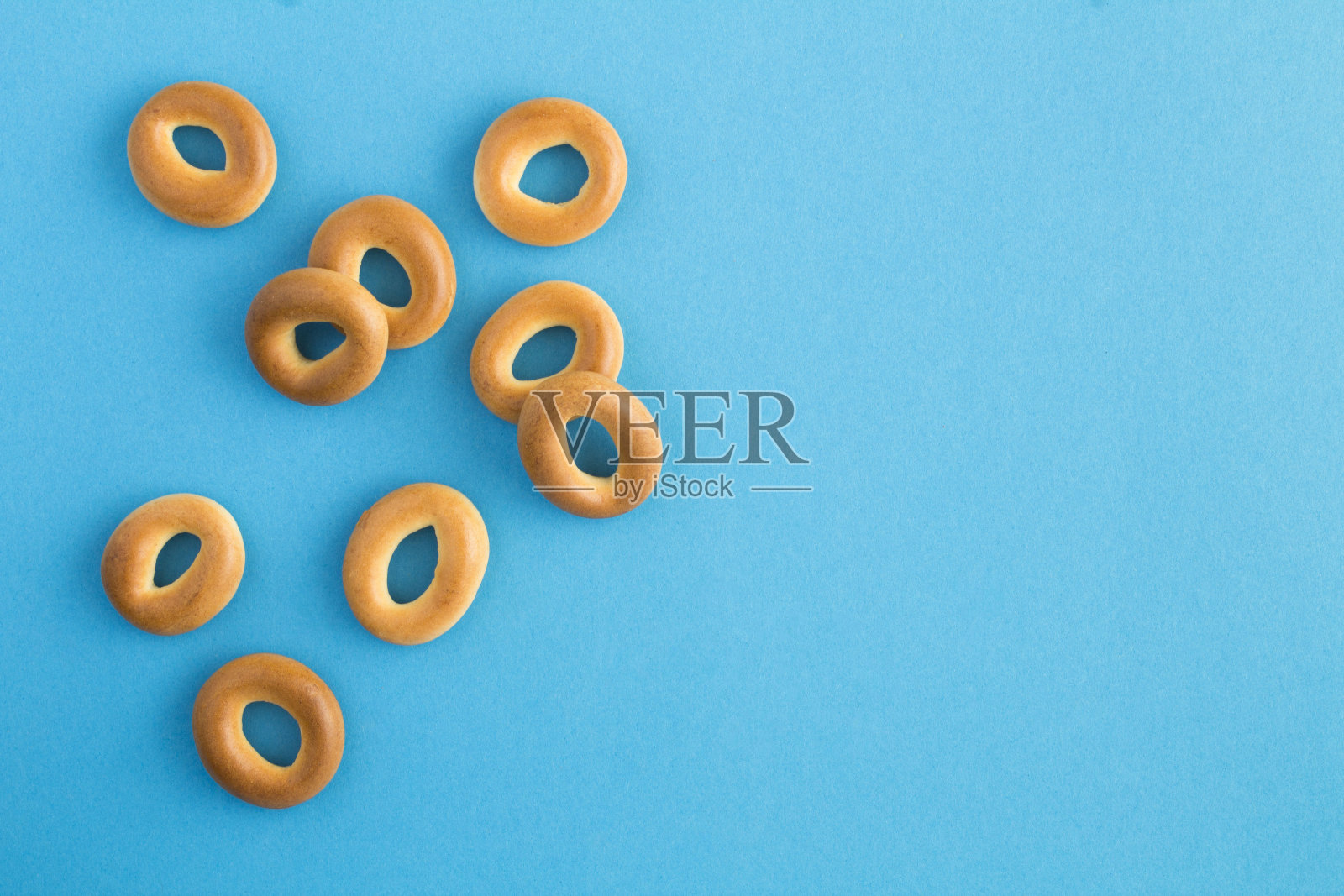 在蓝色背景上的百吉饼。前视图。副本的空间。照片摄影图片