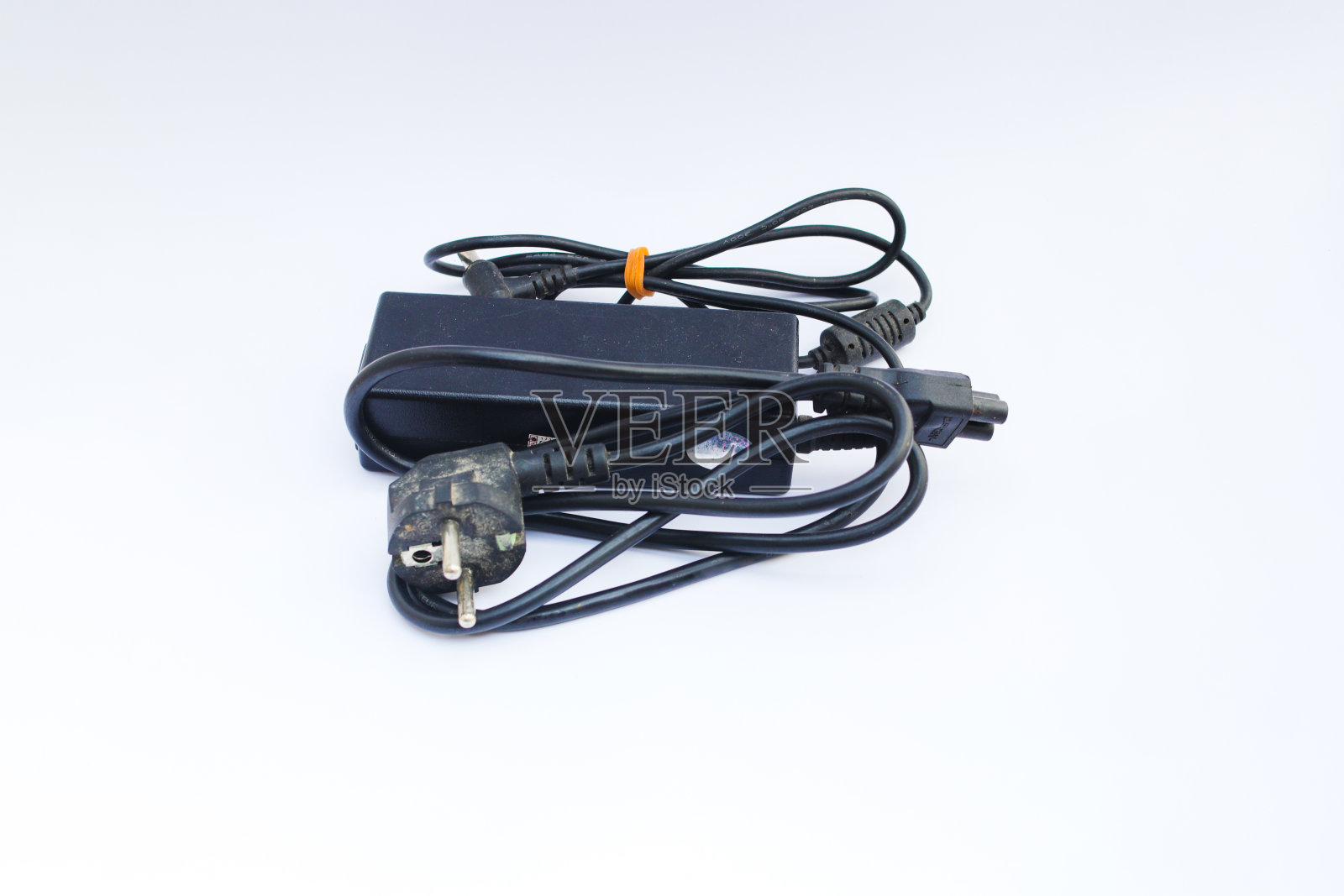 旧的笔记本电脑充电器孤立的白色背景。照片摄影图片