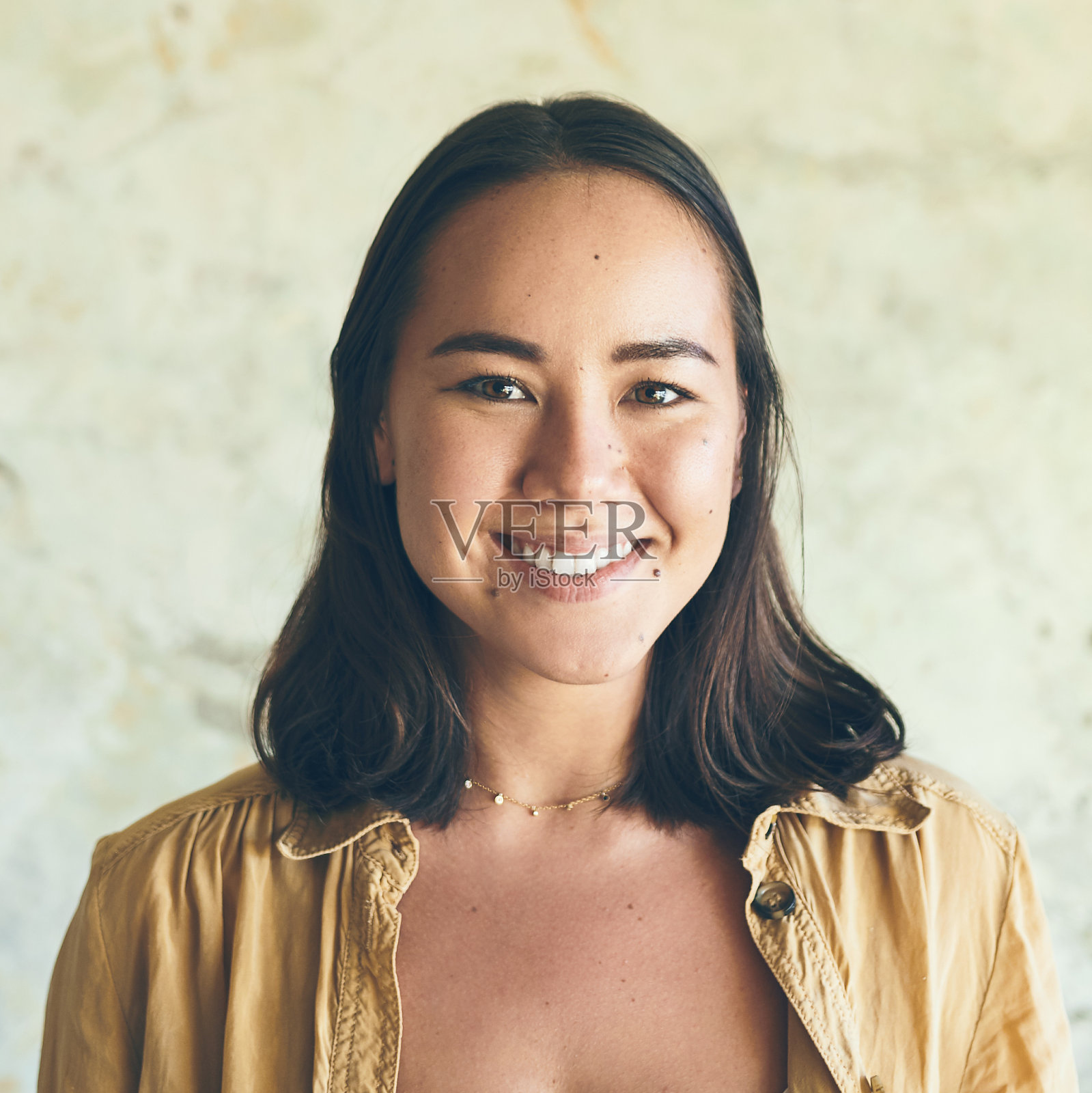 一个自信的年轻女子靠墙站着的肖像照片摄影图片