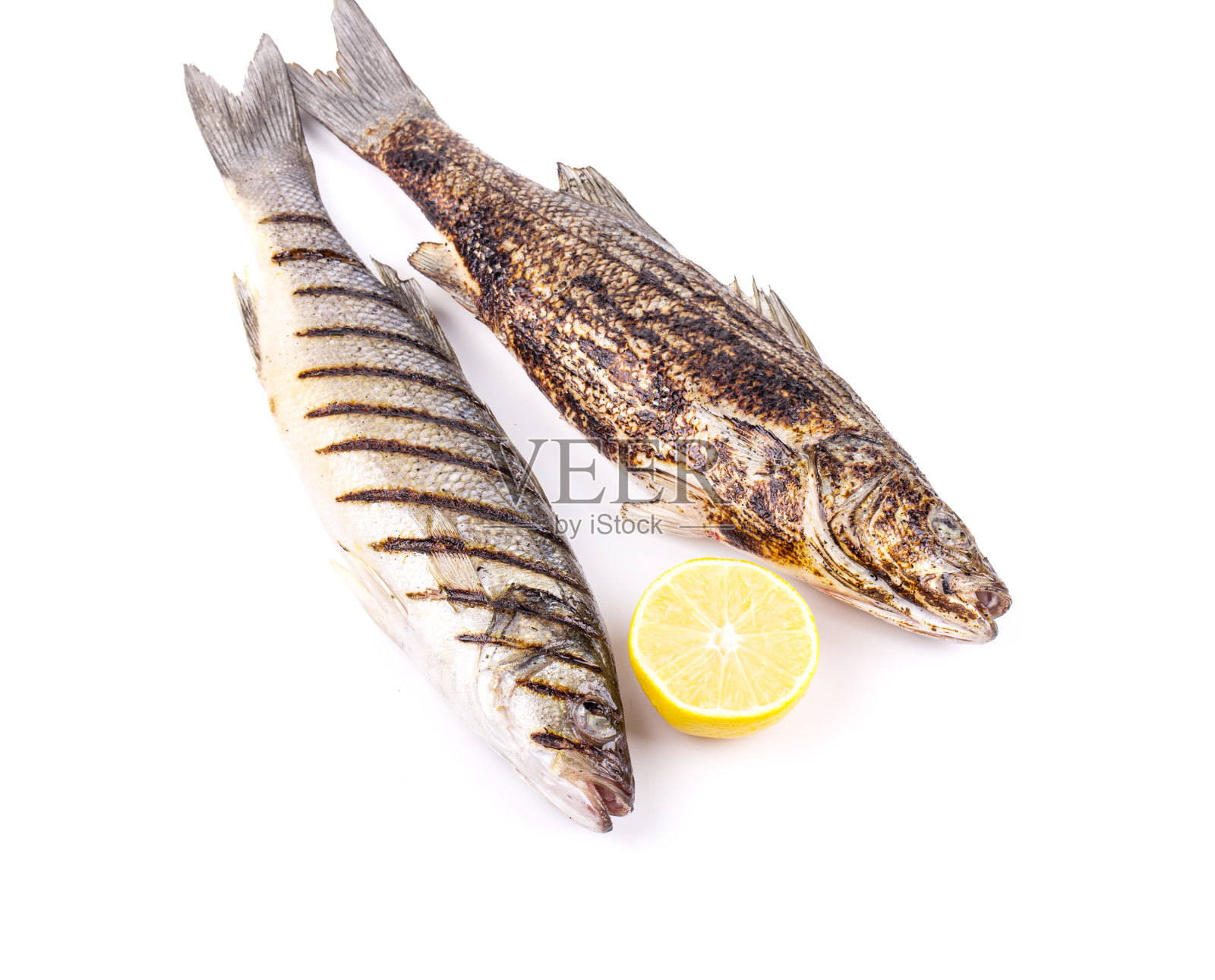 两条炸鱼加半个柠檬。照片摄影图片