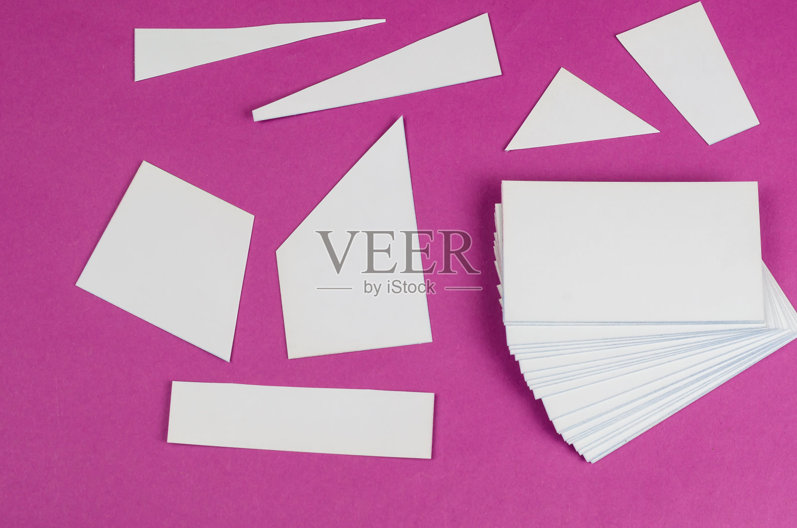 粉红色上有随机的白色几何形状。梯形、长方形、三角形。照片摄影图片