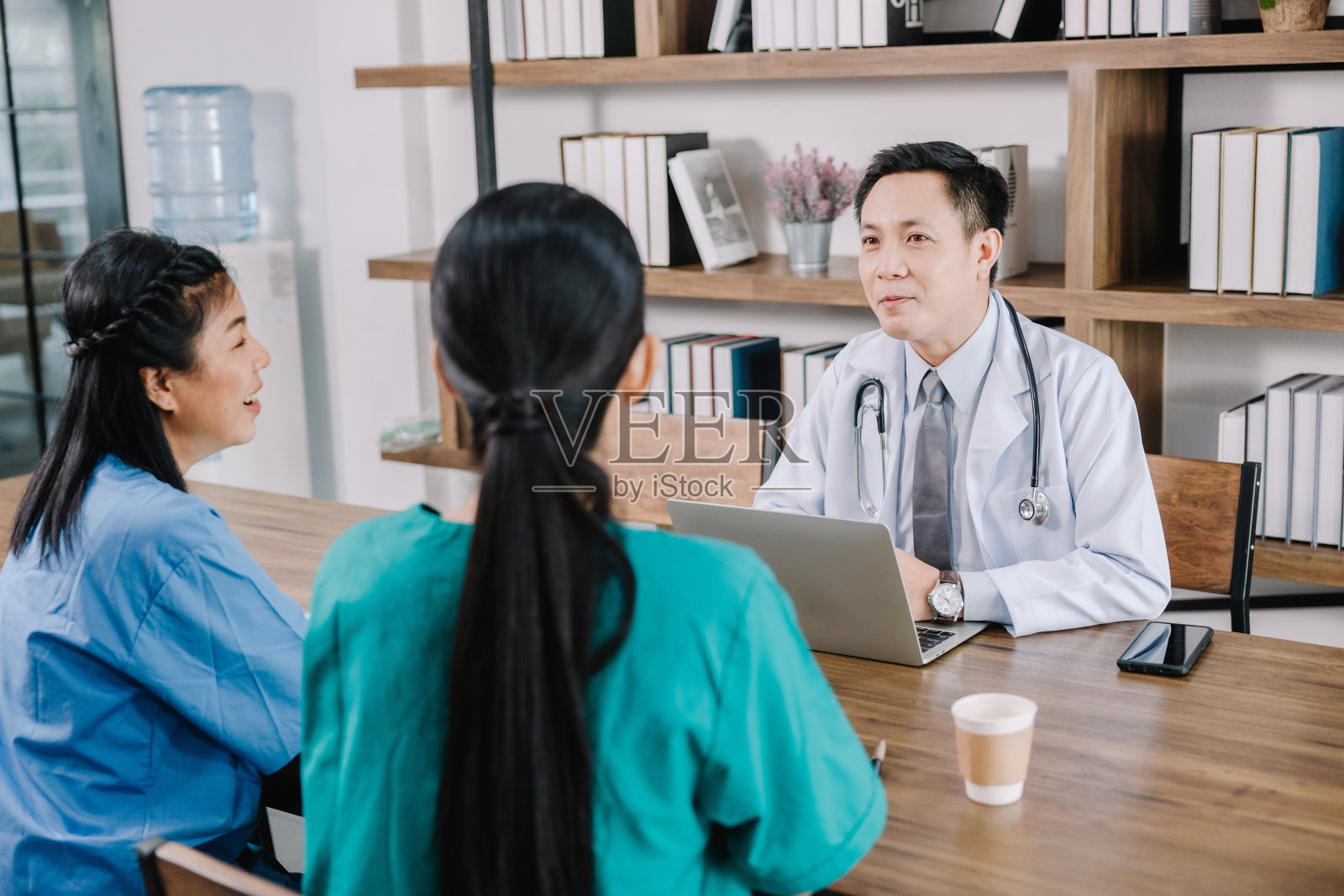 全科医生是咨询、检查和提供建议，诊断健康问题，讨论健康保健和保险病人在诊所，健康保健的概念照片摄影图片