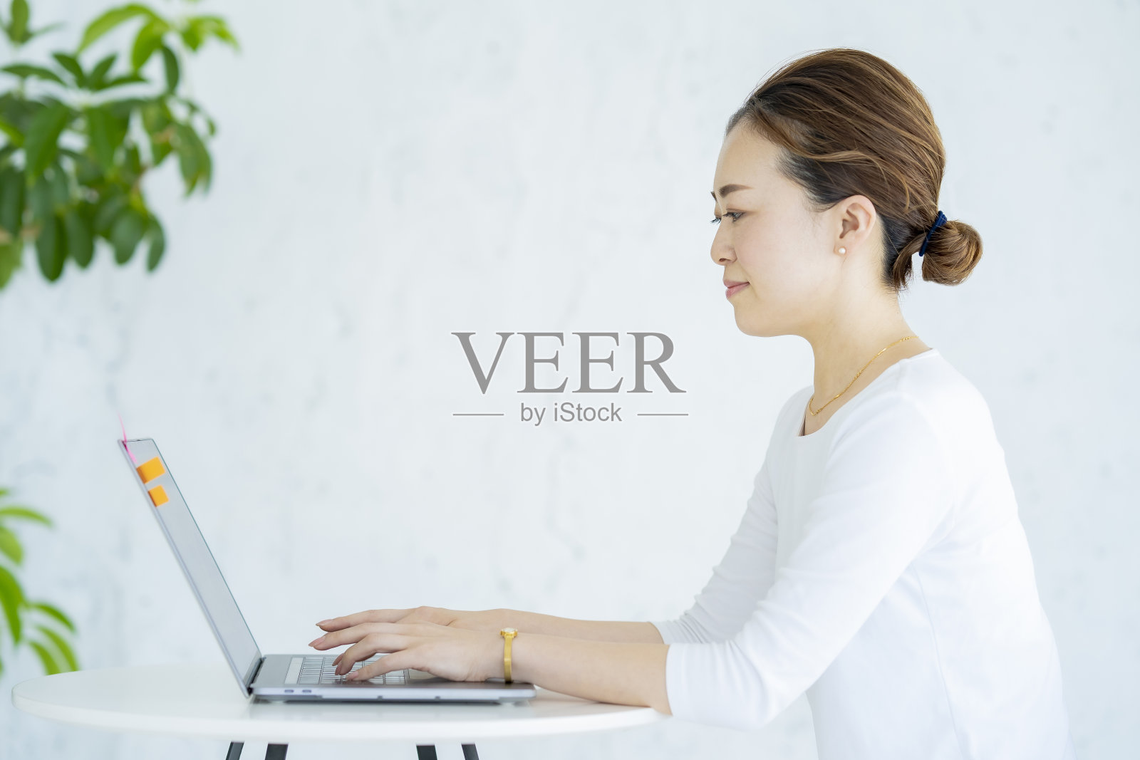 一个在明亮的房间里操作笔记本电脑的女人照片摄影图片