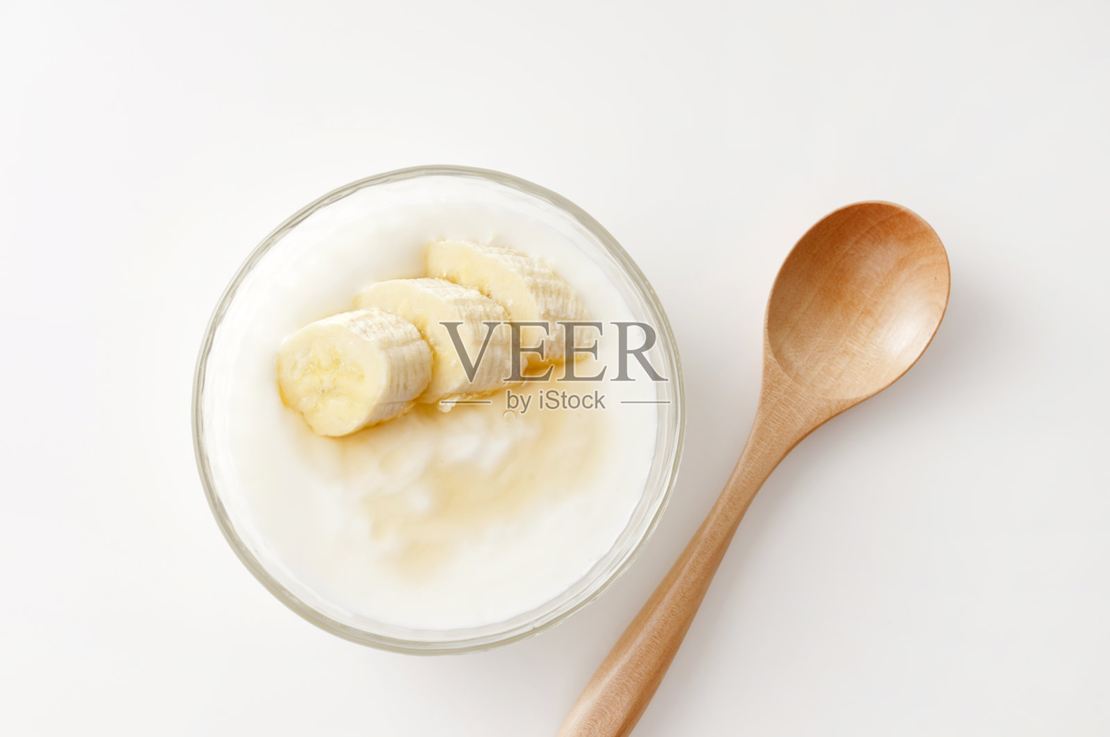 白色背景上有香蕉片的酸奶照片摄影图片