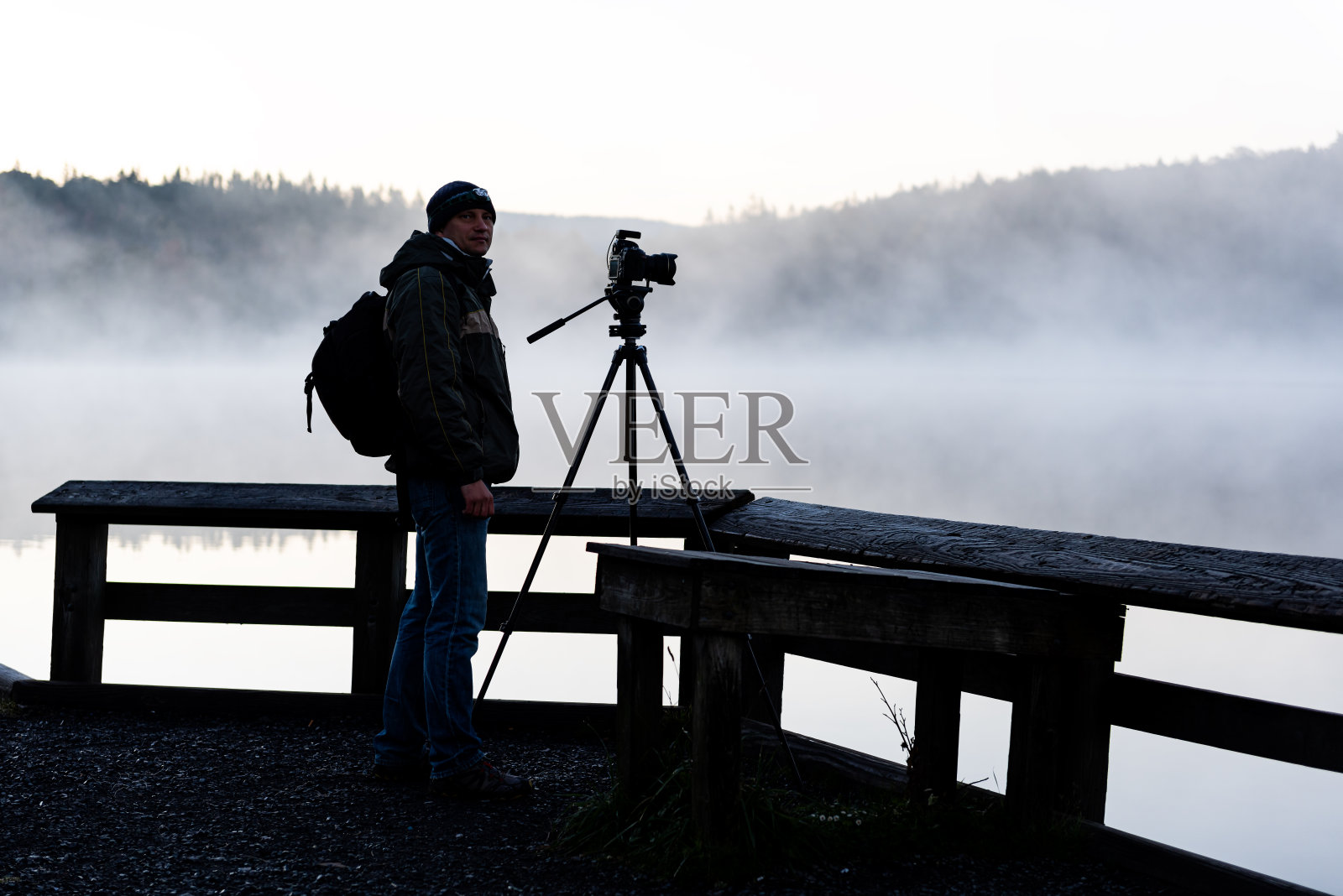 云杉钮湖在西维吉尼亚日出与摄影师与三脚架相机和风景蓝色的水和森林树木与阳光照片摄影图片