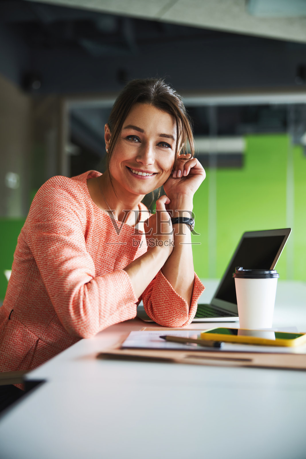 美丽的年轻女性网络营销专家看着和摆姿势的相机照片摄影图片