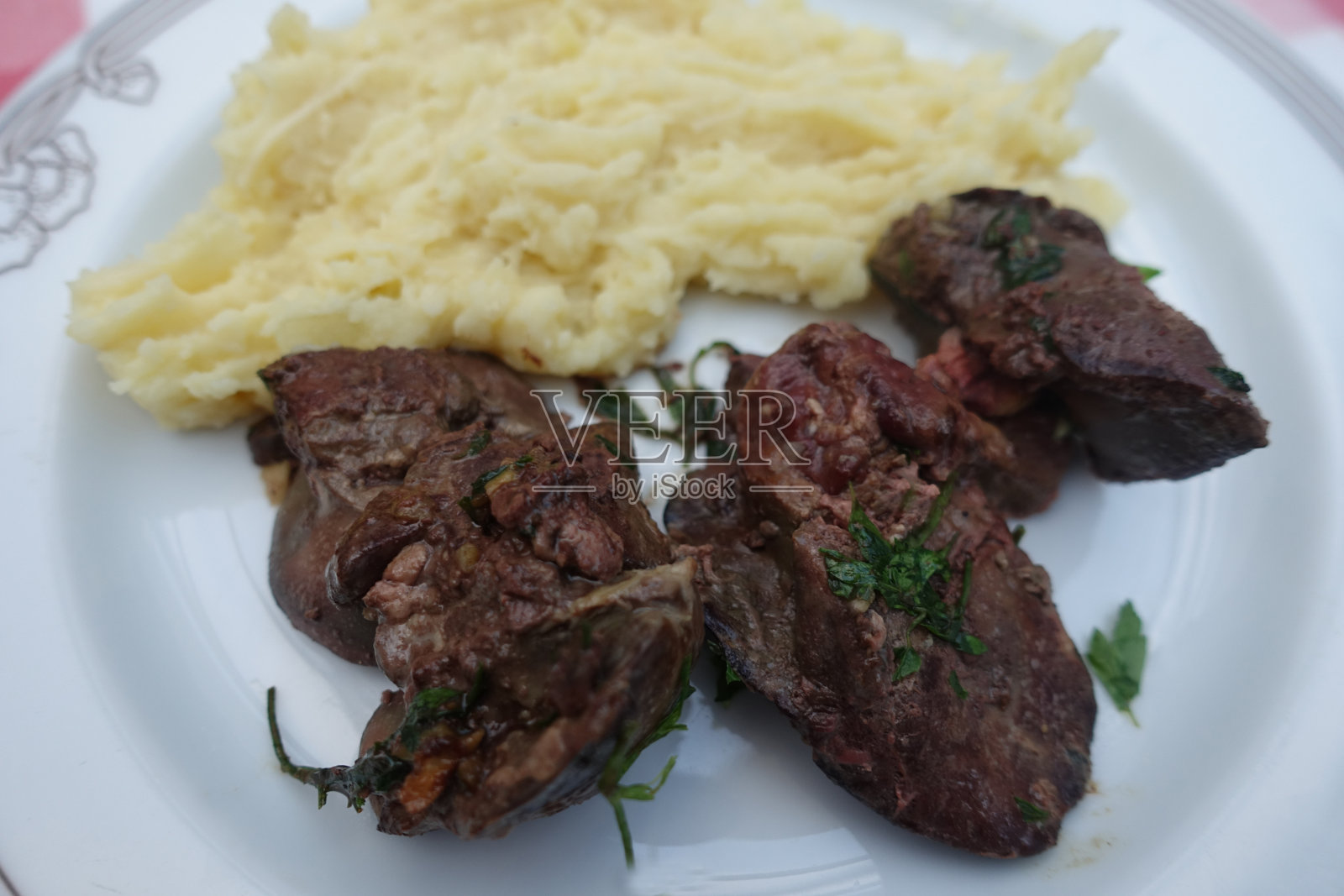 褐鸡肝配蒜蓉和欧芹，配牛奶煮的土豆泥照片摄影图片