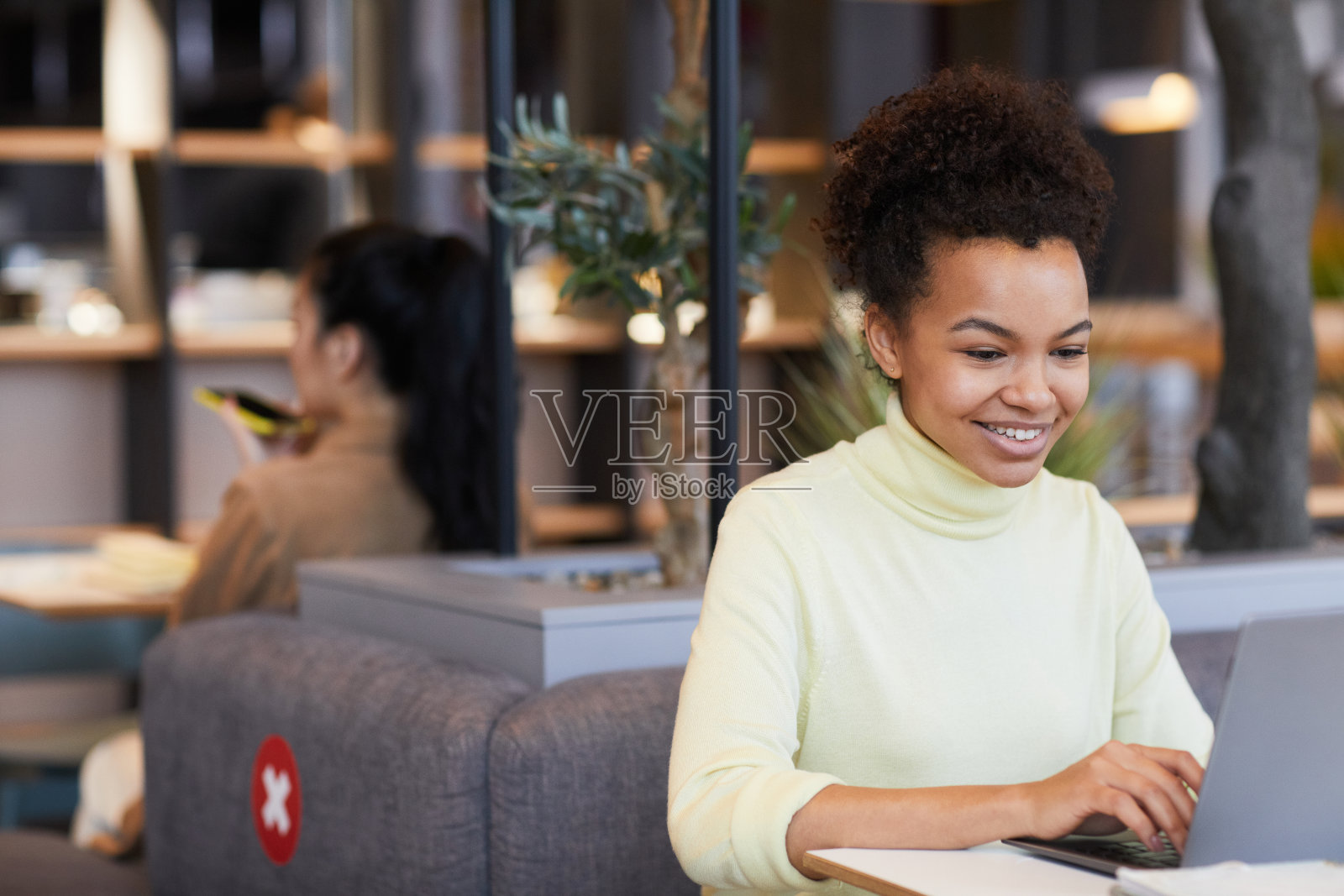 在咖啡桌上工作的微笑女人照片摄影图片