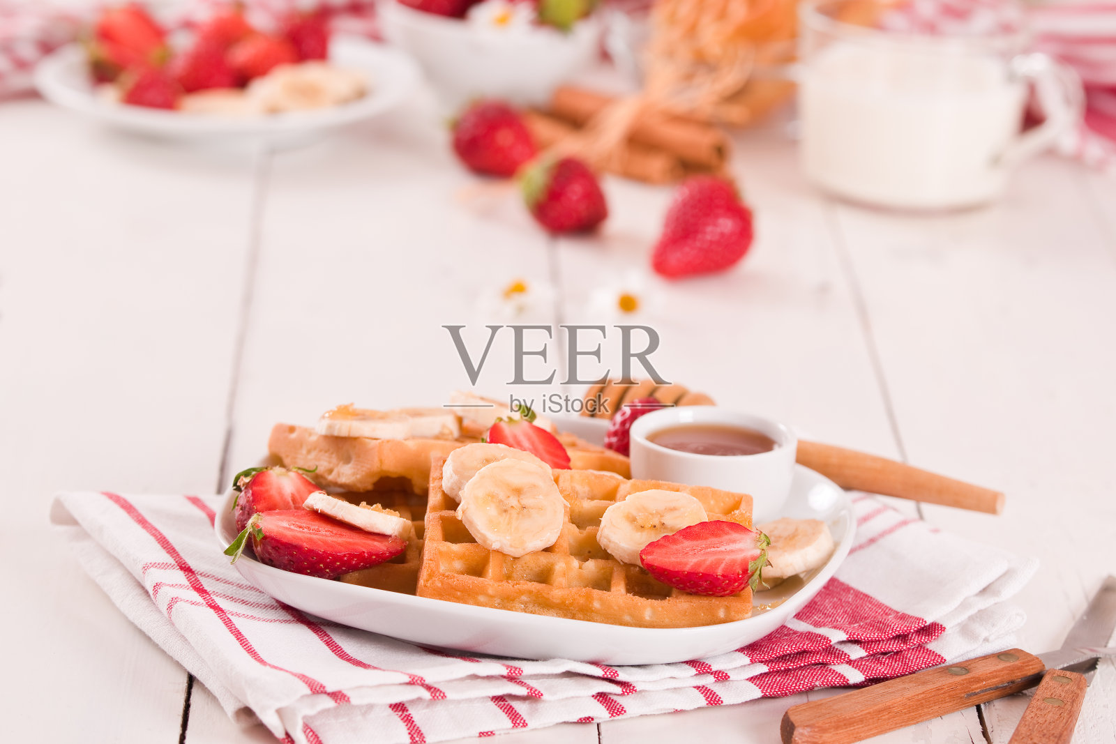 加草莓、香蕉和蜂蜜的华夫饼。照片摄影图片