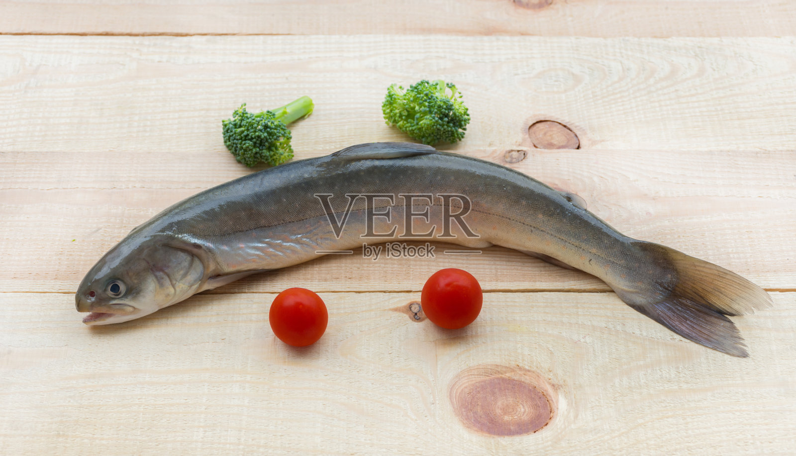 生的彩虹鳟鱼河鱼在木制的背景和蔬菜照片摄影图片