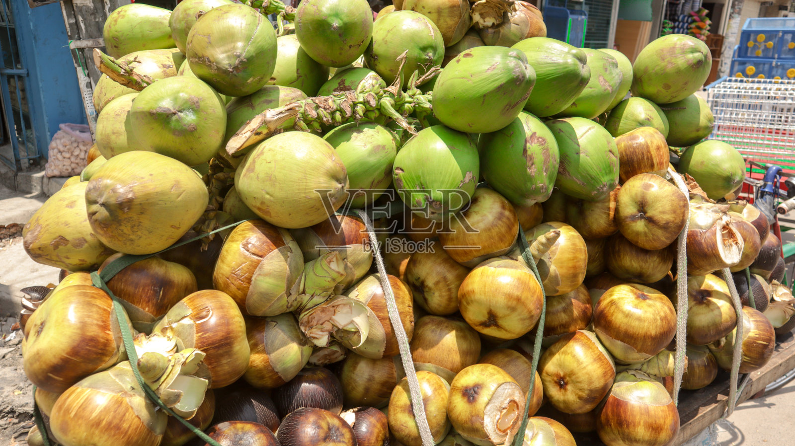 孟加拉国达卡的街头小贩在一辆货车上出售成熟的棕榈和绿椰子照片摄影图片