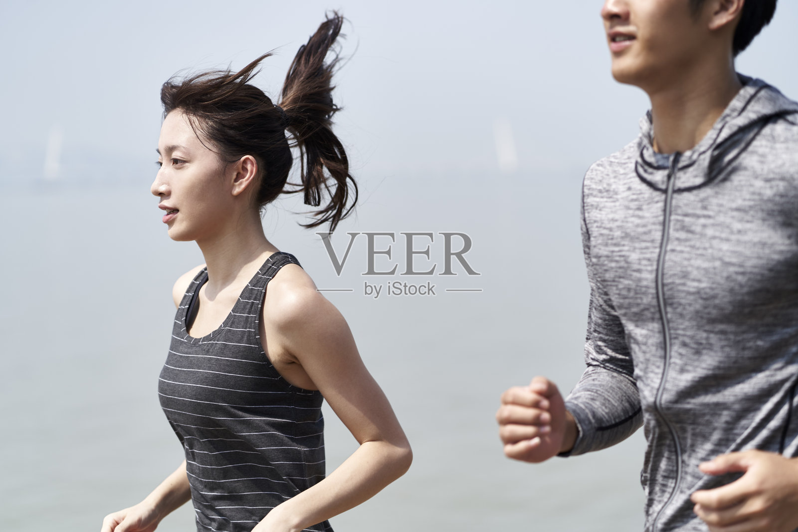 年轻的亚洲夫妇在海滩上跑步照片摄影图片