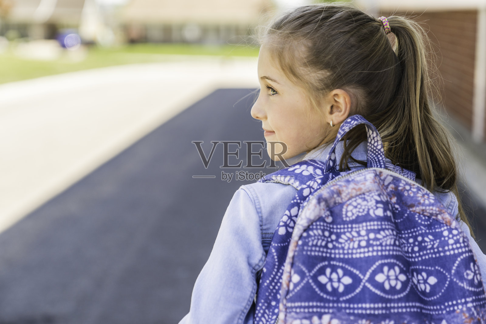 小女孩在学校操场上背着背包照片摄影图片