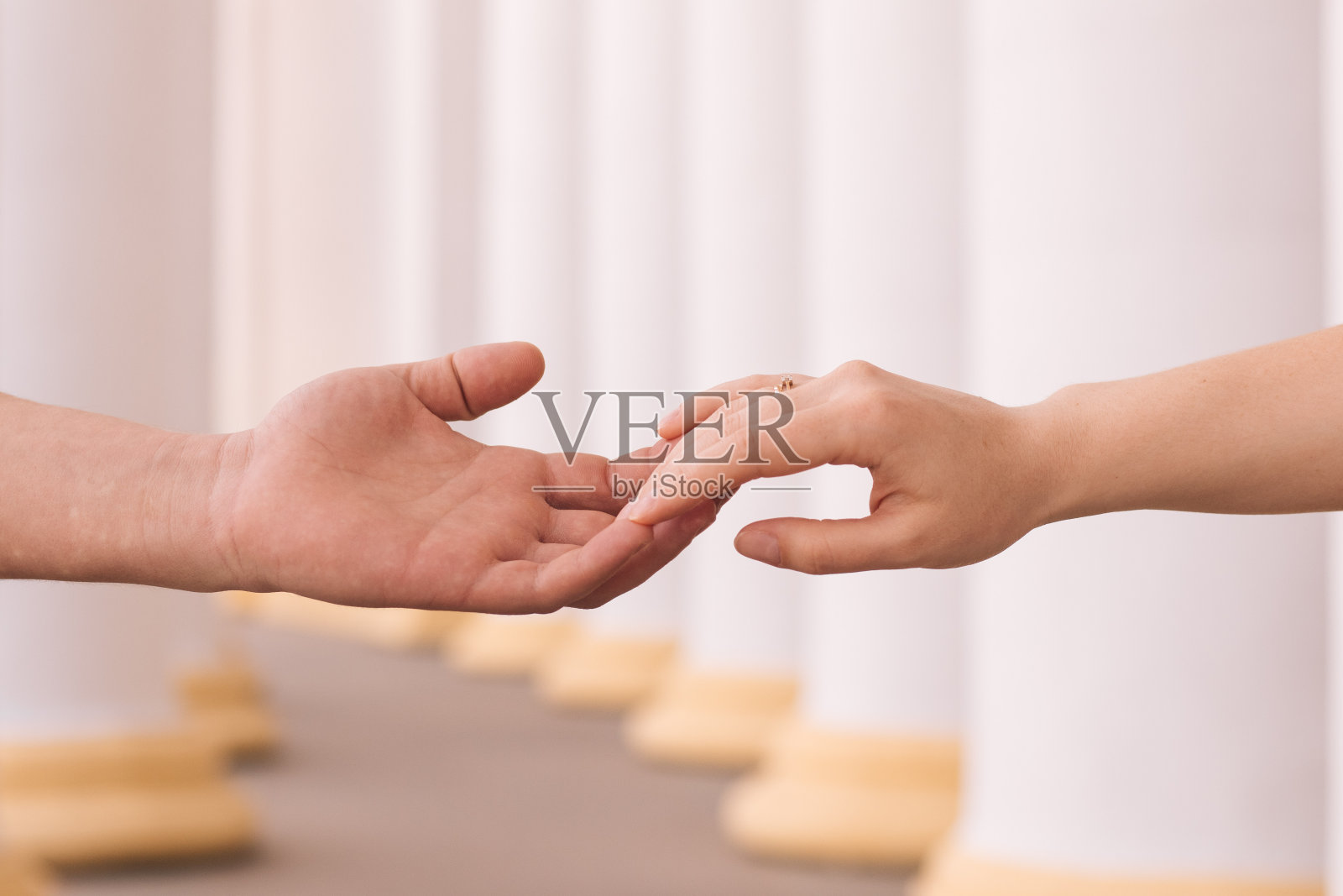 在模糊的背景上，这对相爱的夫妇手牵着手照片摄影图片