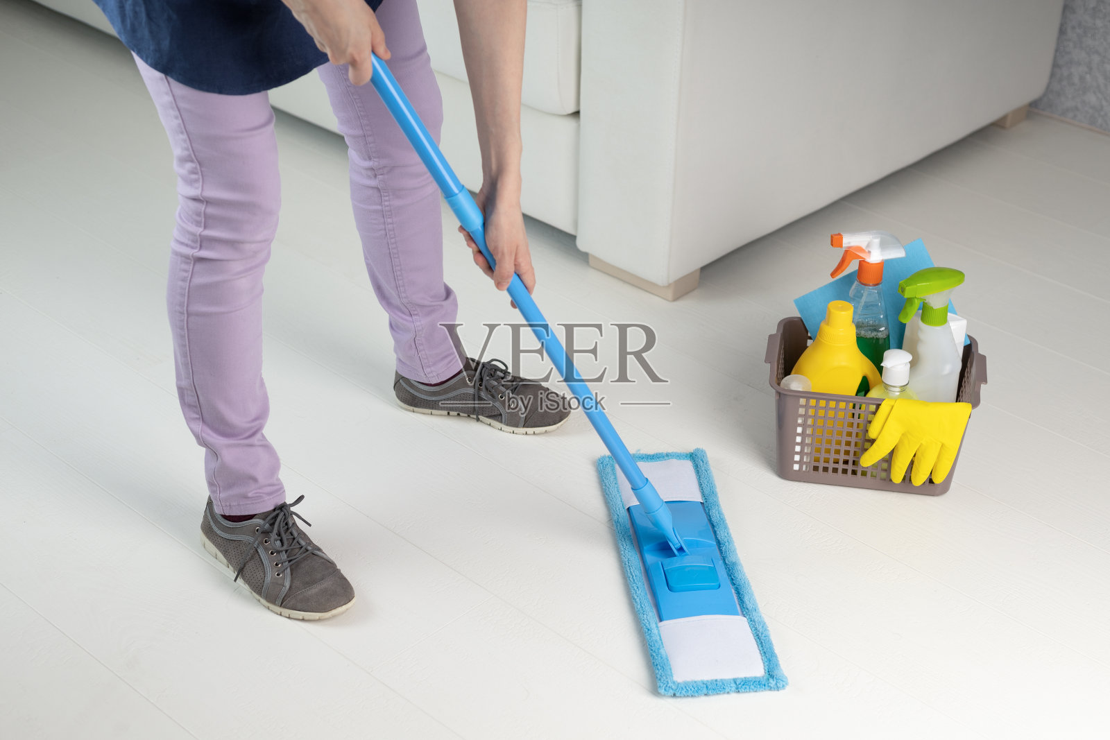 贴身女保洁员在打扫房间的地板。女人做家务。照片摄影图片