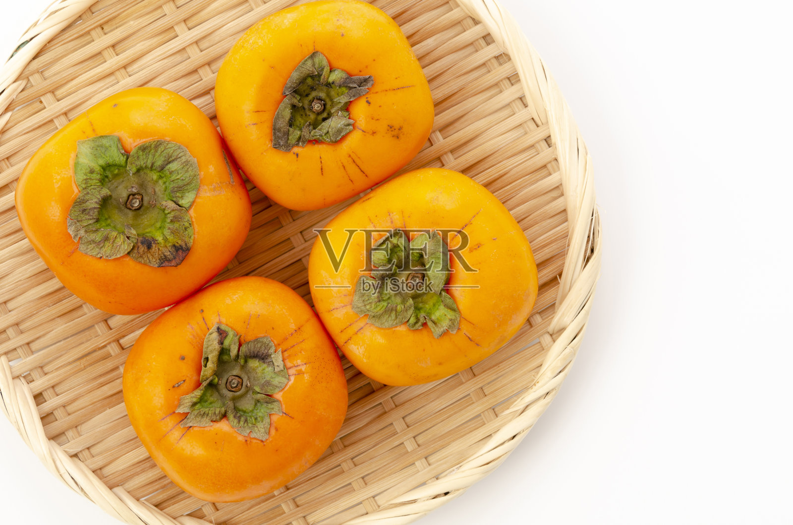 柿子果，竹筛上白底照片摄影图片