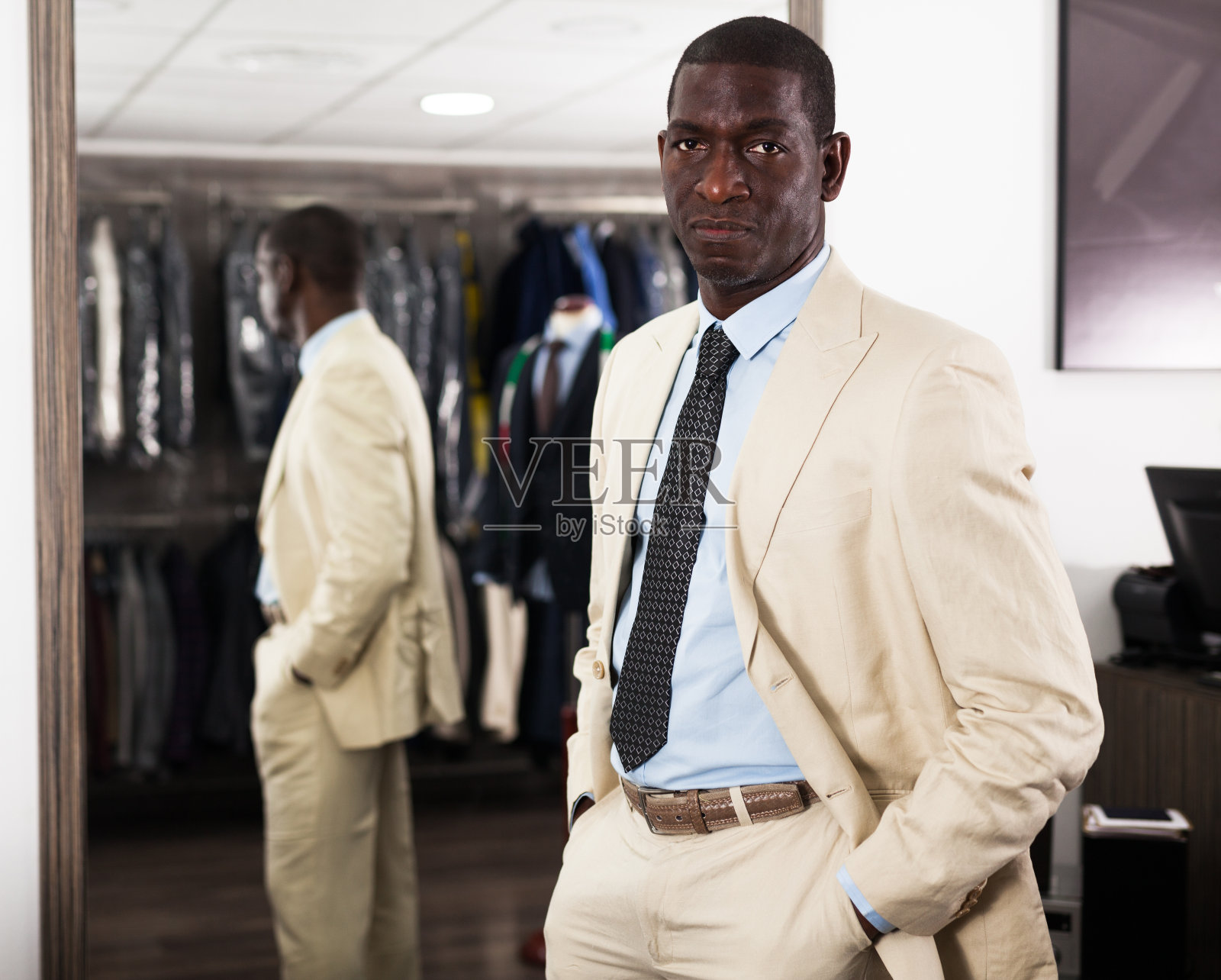 男性客户在商场中选择经典的米色夹克的肖像照片摄影图片