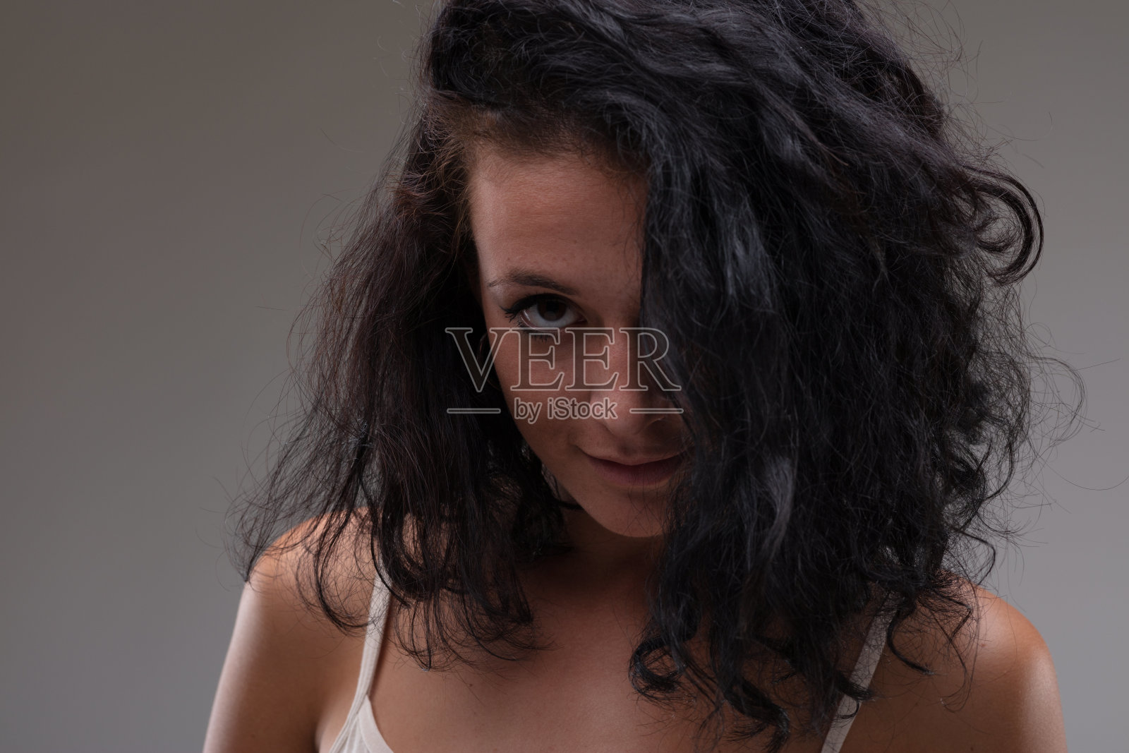 迷人的年轻女子，头发遮住了一只眼睛照片摄影图片