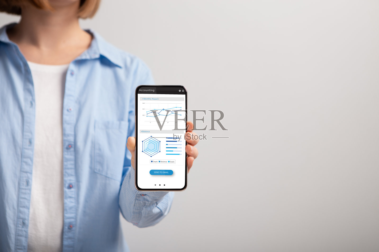 一个不认识的女人拿着智能手机，屏幕上有各种图表照片摄影图片